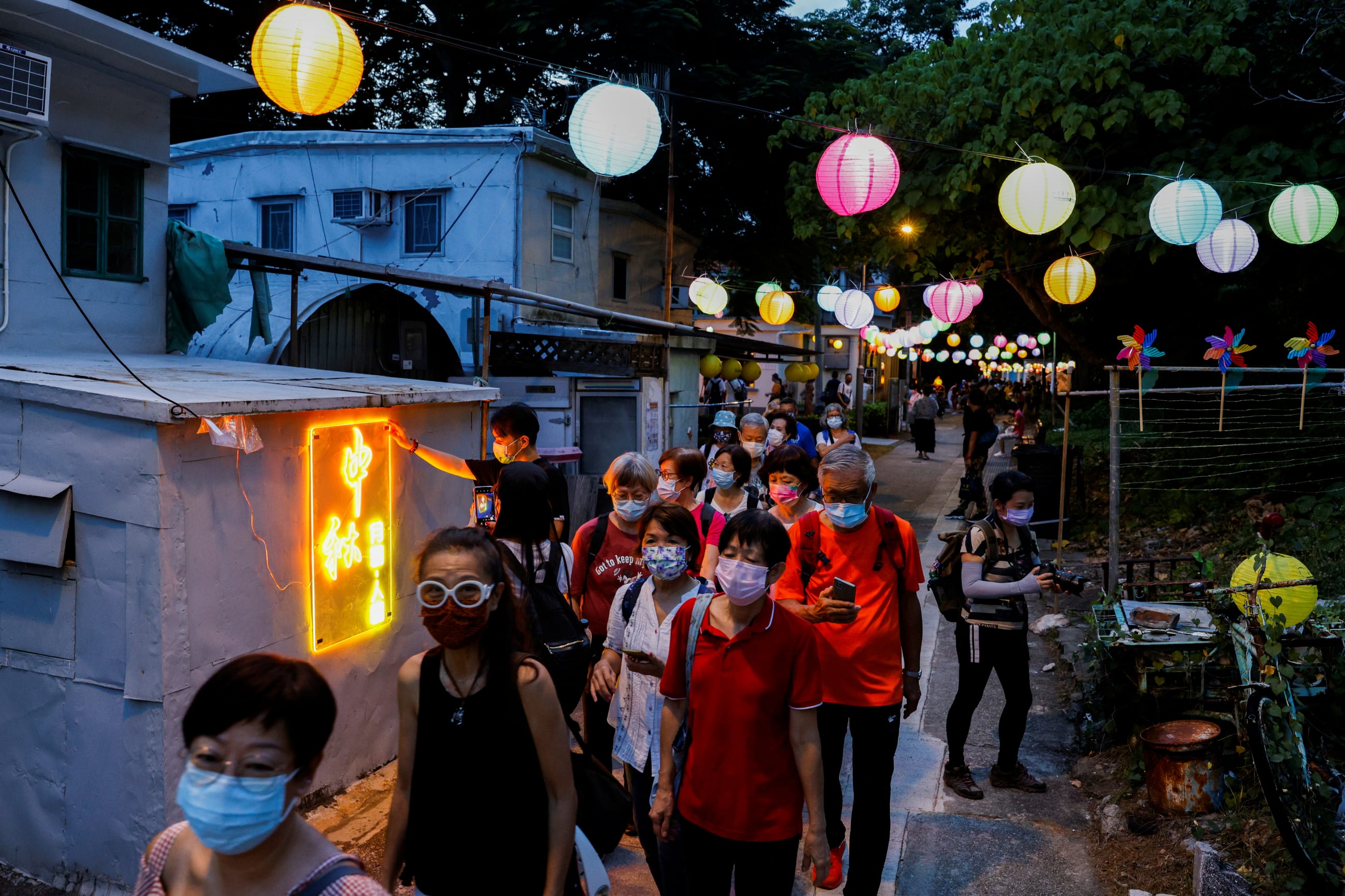 People walk near Chinese lanterns ahead of Mid-Autumn Festival at Tai O, in Hong Kong, China September 14, 2021.
