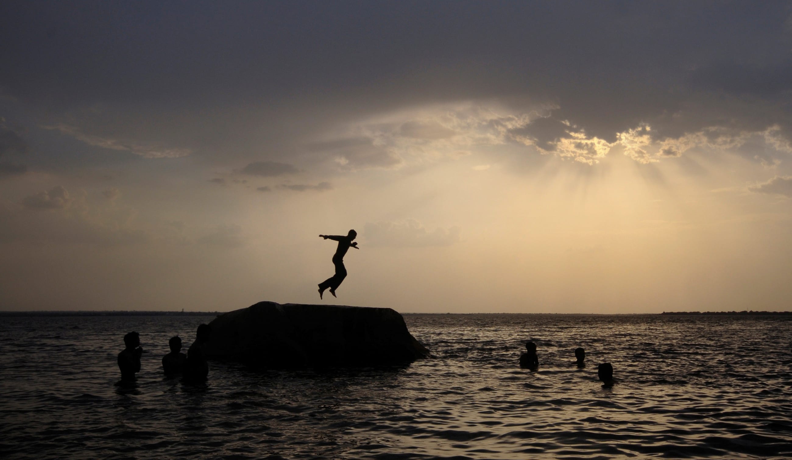 A boy prepares to jump off a rock into the waters of the Osman Sagar Lake near the southern Indian city of Hyderabad May 29, 2011.
