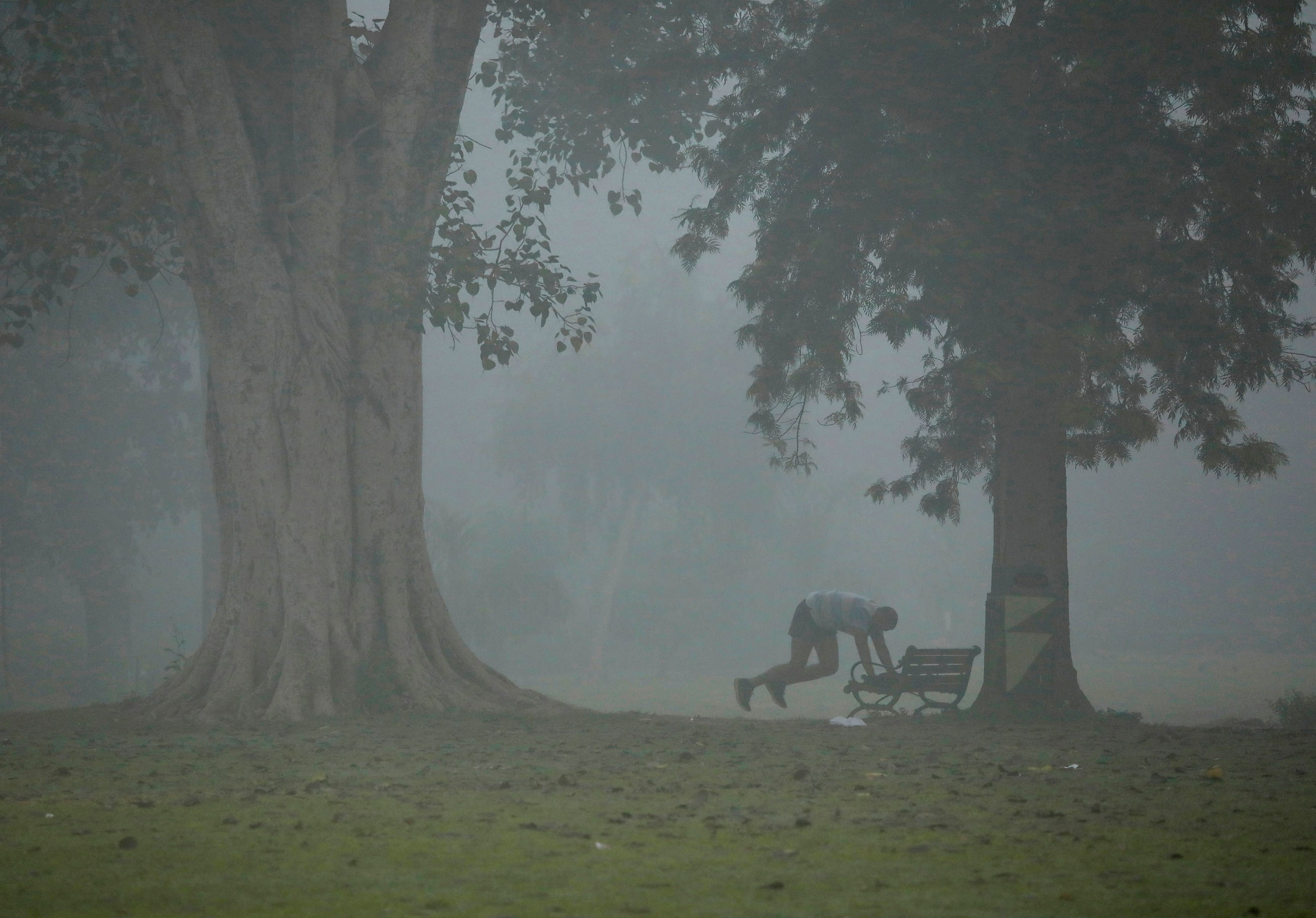 A man exercises in a park on a smoggy morning in New Delhi, India, on November 9, 2017.
