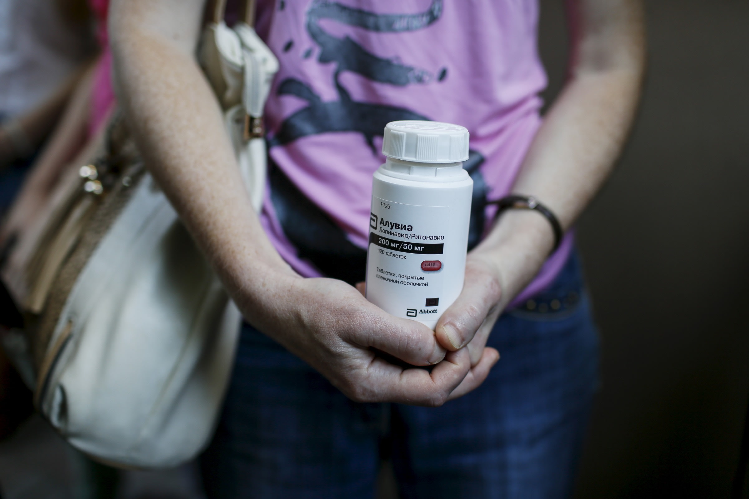 An activist of the All-Ukrainian Network of People Living With HIV/AIDS, a non-governmental group, holds an empty package of the drug Aluvia, as she takes part in a rally in front of the Ukrainian cabinet of ministers building in Kiev, Ukraine, July 1, 2015.