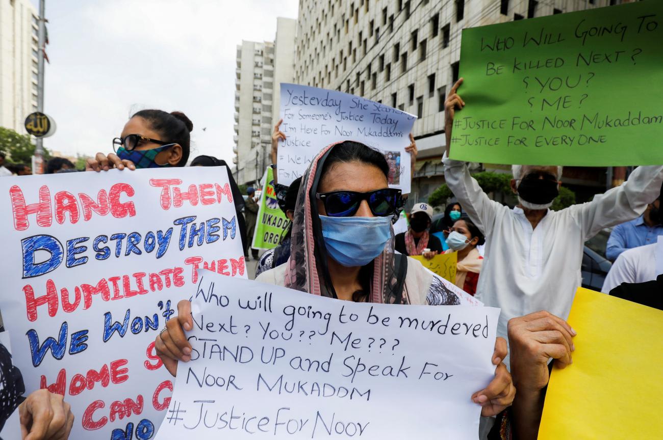 Women carry signs against the killing of Noor Mukadam, daughter of former Pakistani diplomat, and to condemn violence against women and girls during a protest in Karachi, Pakistan, on July 25, 2021.