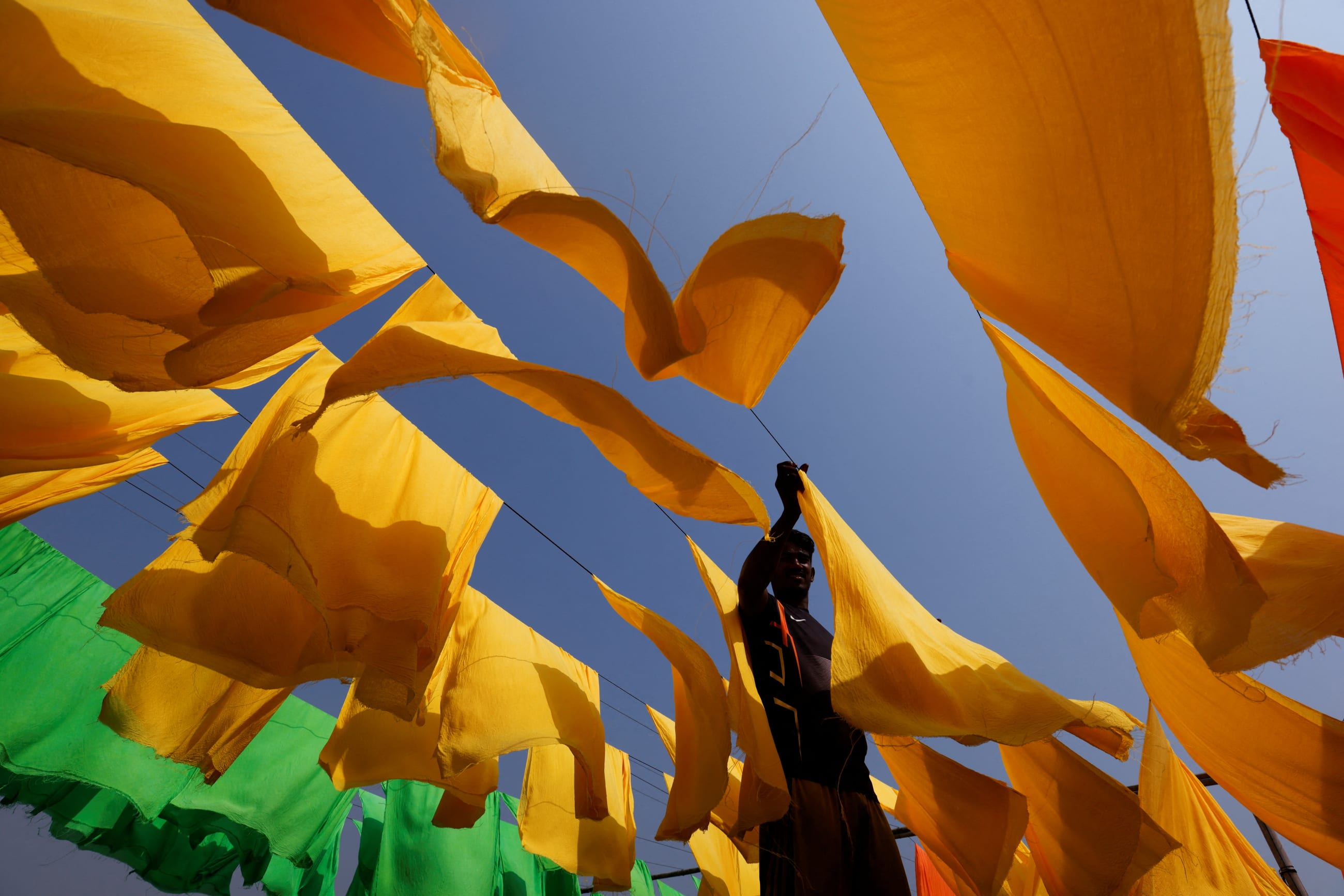 A worker dries fabrics at a dye factory in Narayanganj, Bangladesh, on March 9, 2022.