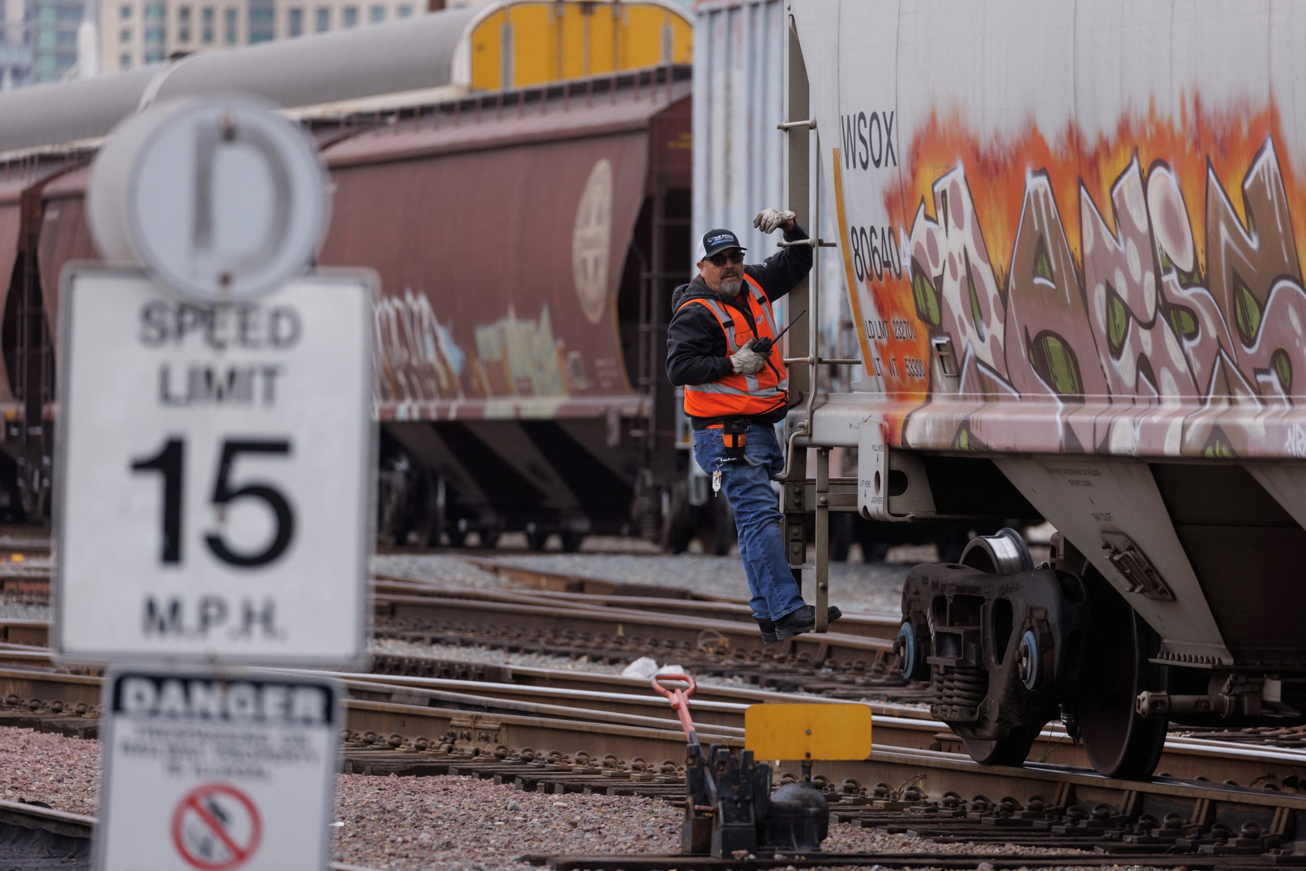 A railway worker helps load railcars onto a train in San Diego, California, U.S., November 30, 2022. 