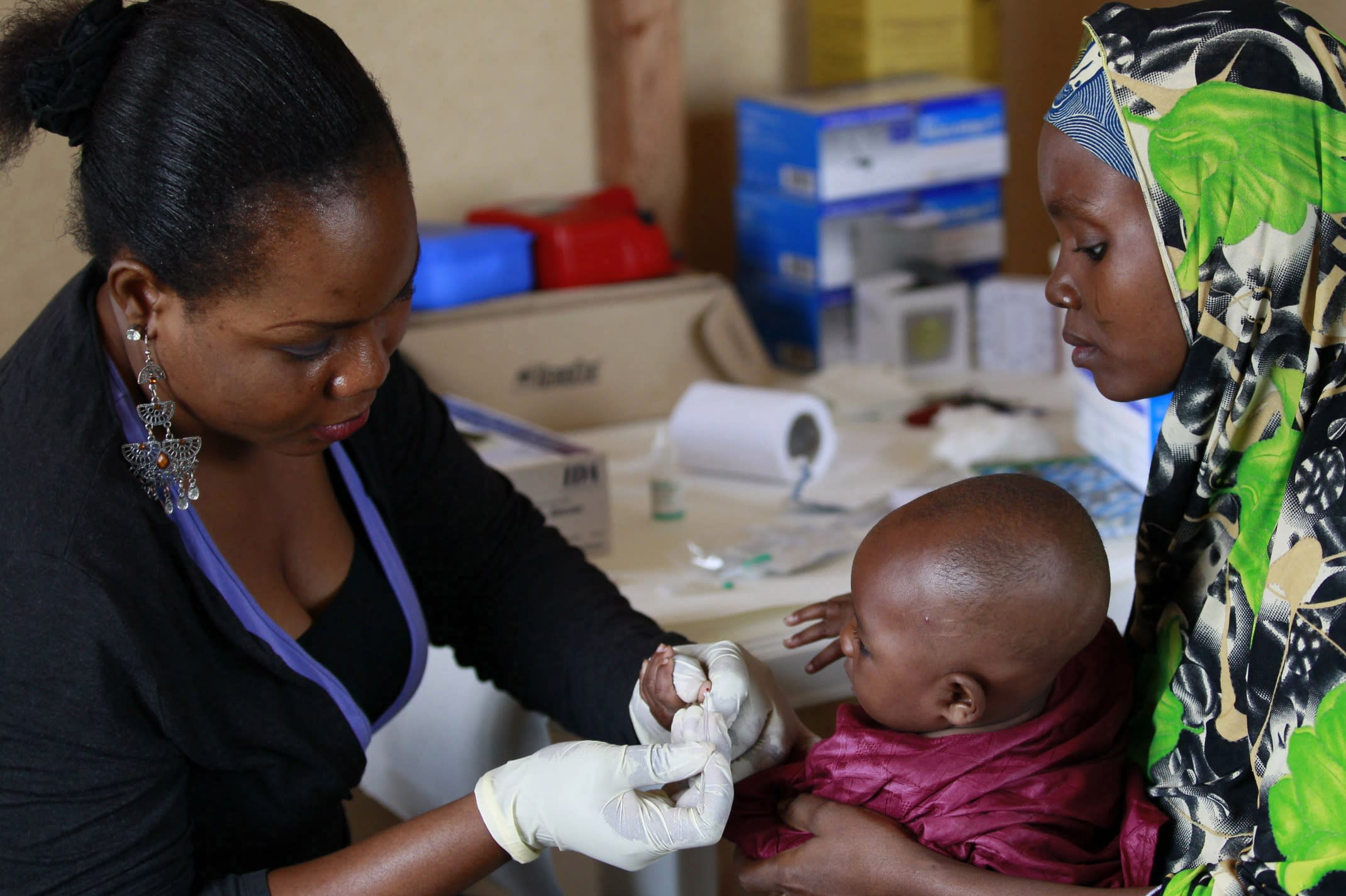 A health staff member takes a blood sample from a child at a clinic operated by Doctors Without Borders in Bagega Village in northwestern state of Zamfara, Nigeria, on August 14, 2013.