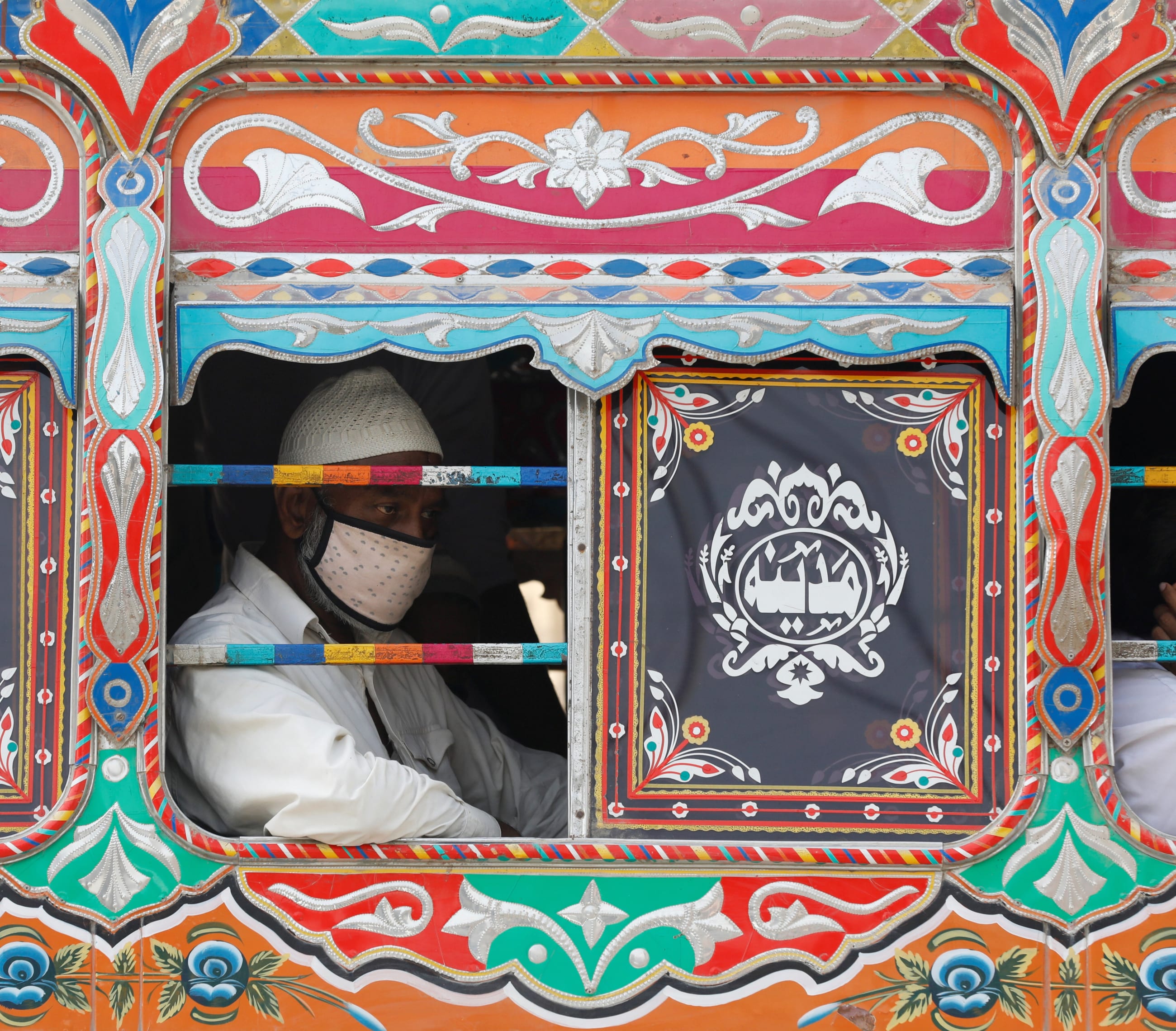 A passenger wearing a protective face mask is seen from the window of a bus in Karachi, Pakistan, on June 3, 2020.