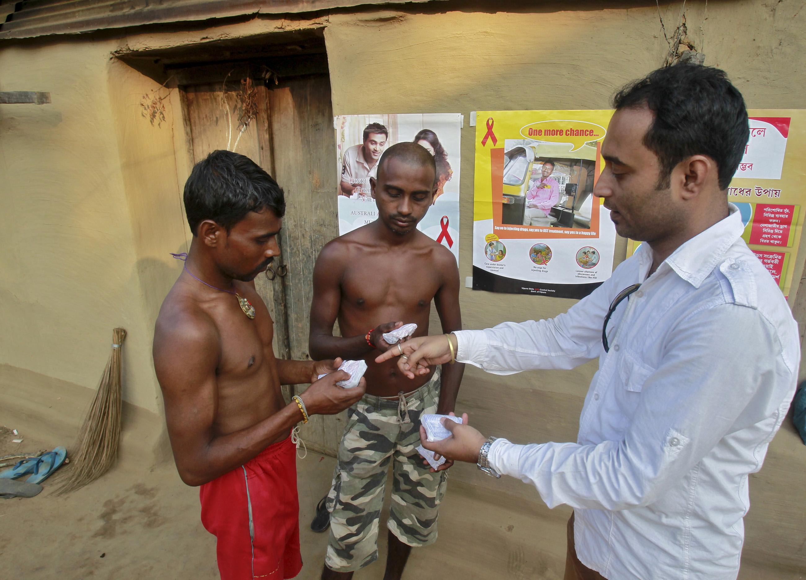 DOCUMENT DATE:&nbsp; November 06, 2015&nbsp; A volunteer (right) from a nongovernmental organization distributes free condoms to villagers during an AIDS awareness campaign on the outskirts of Agartala, India, on November 6, 2015. 