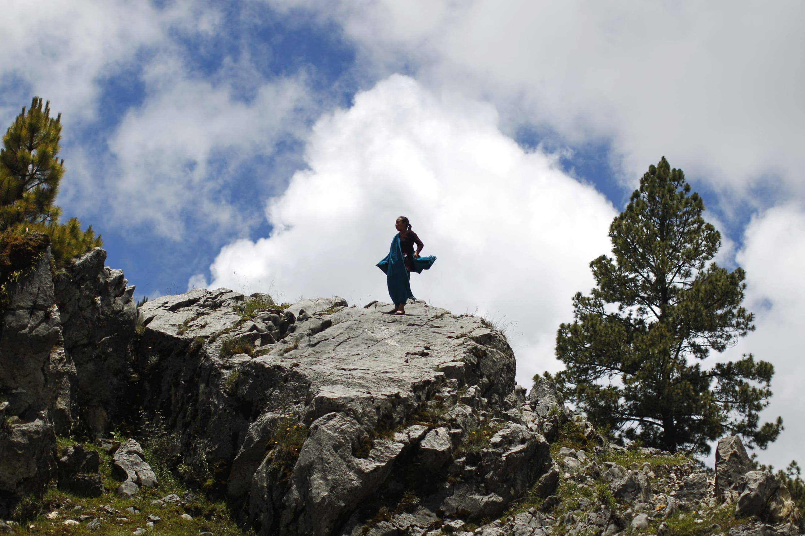 A woman stands on a rock along the road to San Jose Las Flores, Chiantla, in the northern region of Huehuetenango,