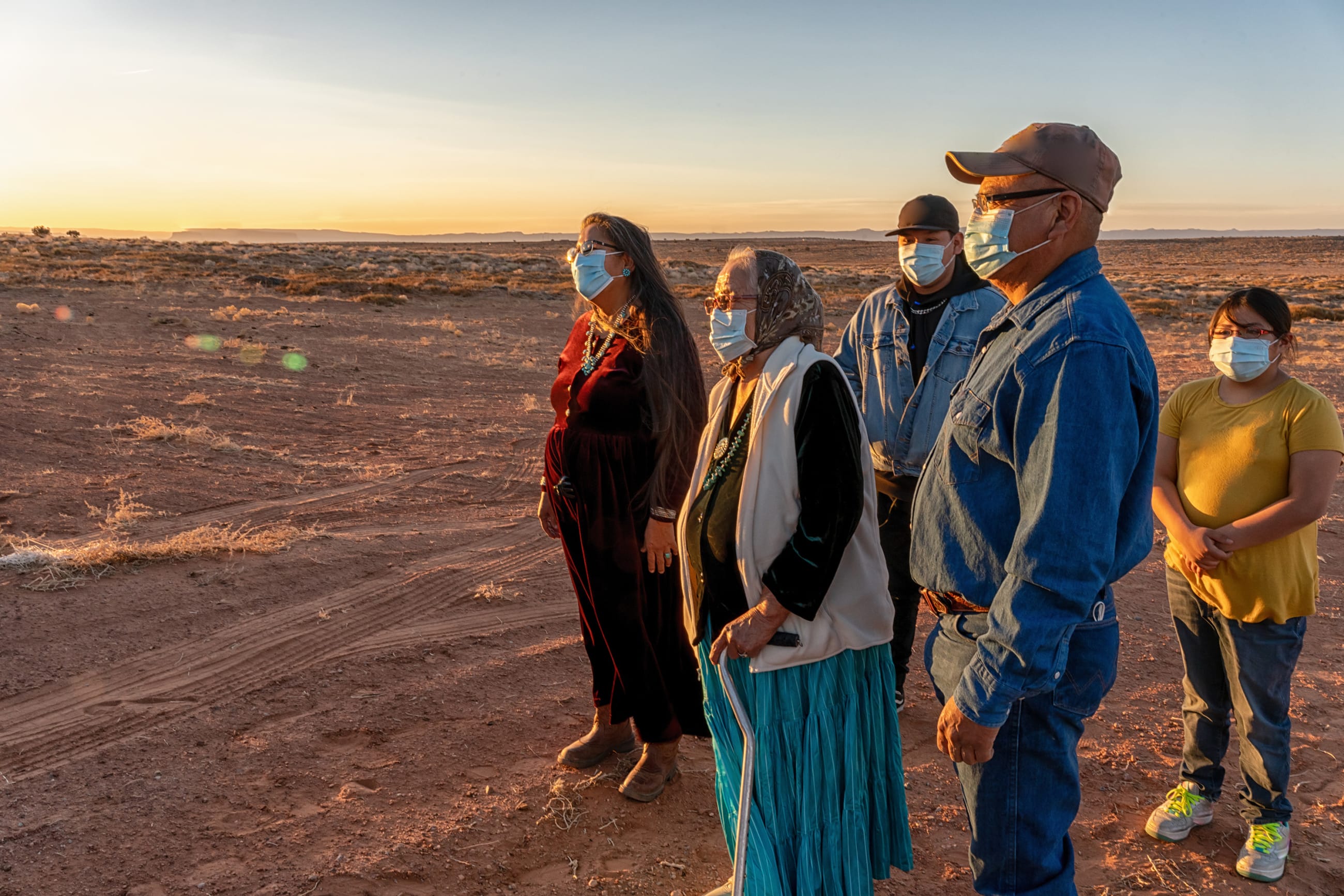 Native American family watching the sunset wearing masks for protection.