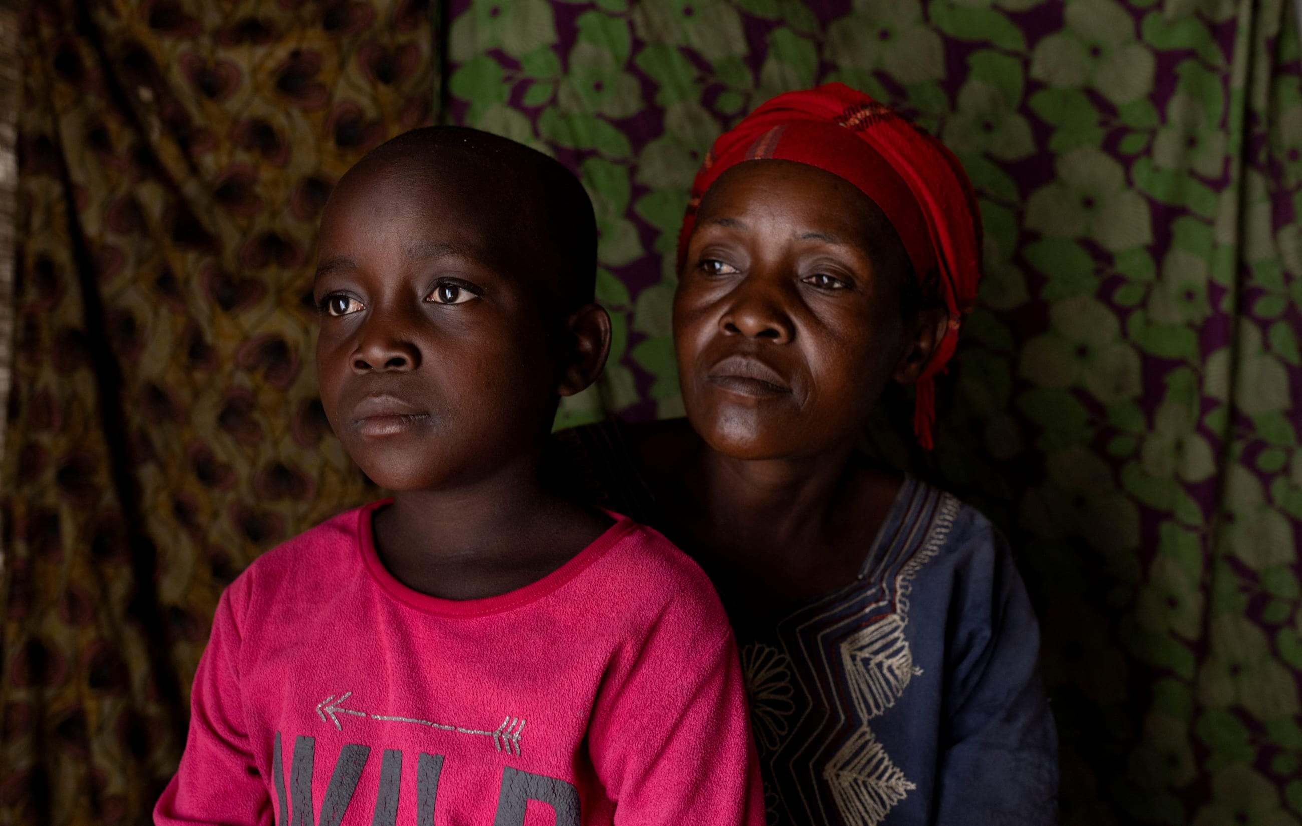 Fideline Kiza Kasao and her son Kito Balume both who recovered from mpox, pose for a photograph inside their shelter.