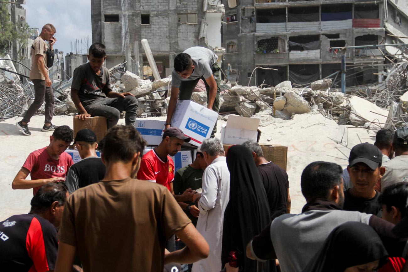 Palestinians gather to receive aid, including&nbsp;food&nbsp;supplies provided by World&nbsp;Food&nbsp;Program, outside a United Nations distribution center.