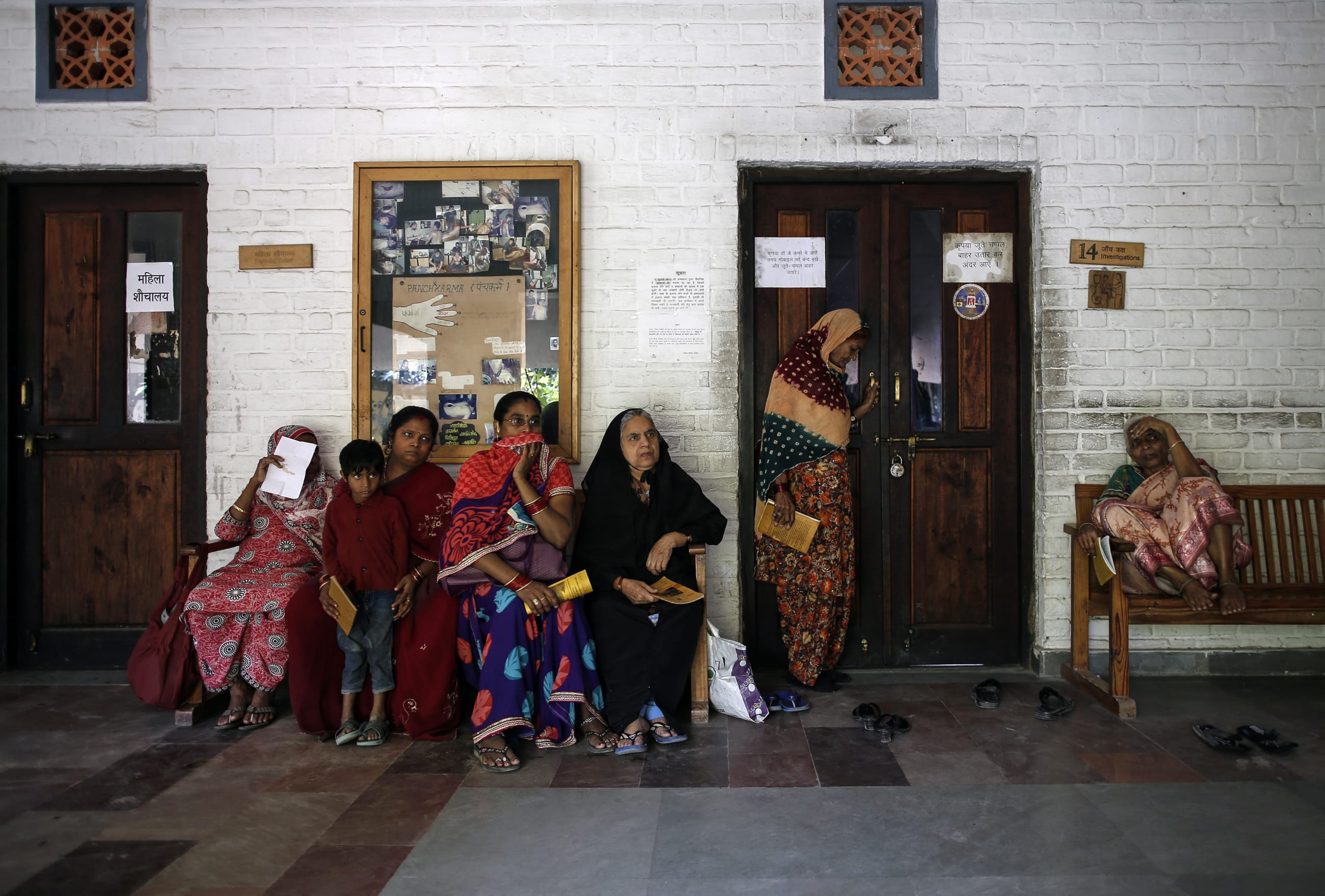 People wait to receive medicine at a clinic.