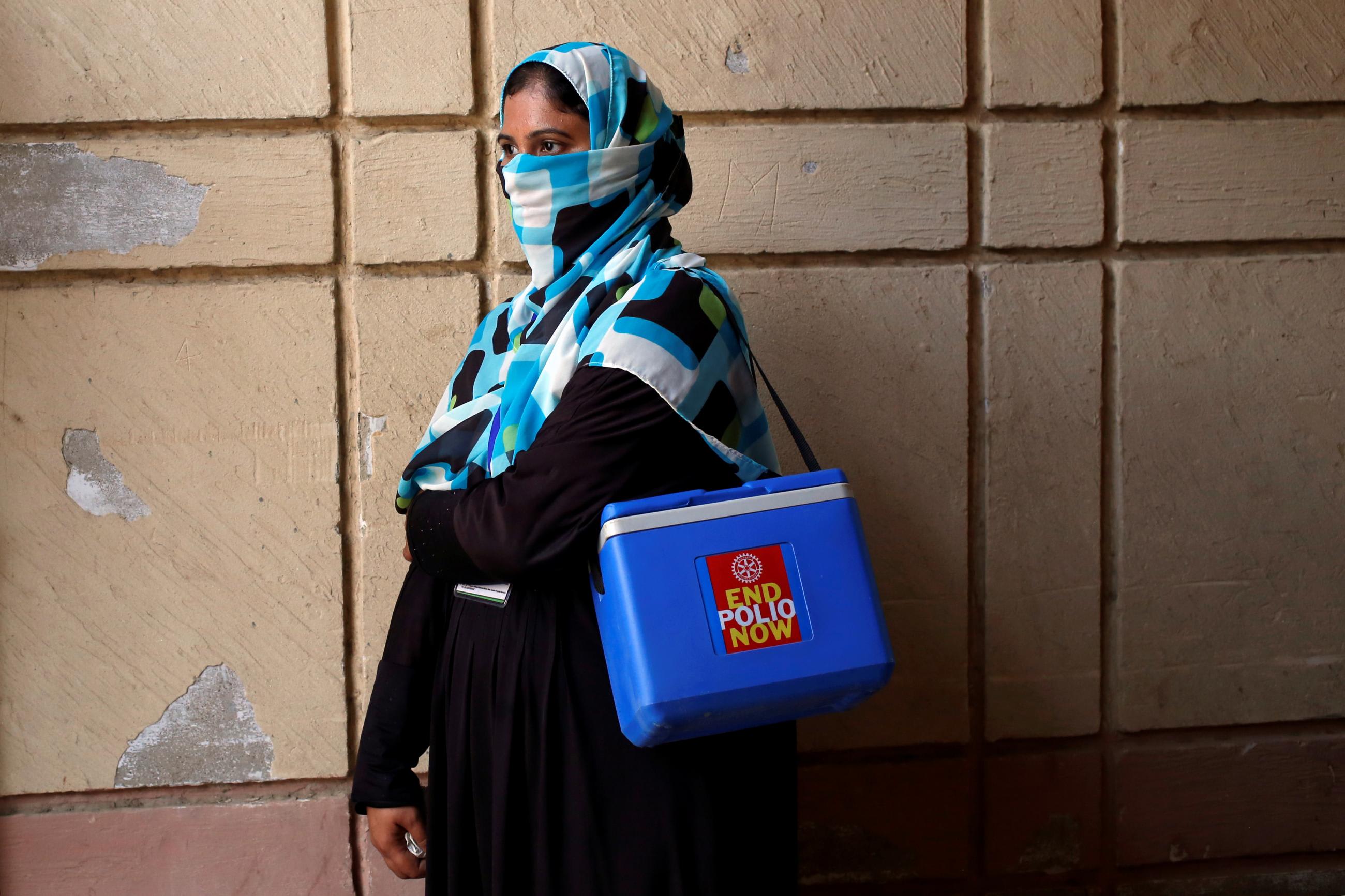 A vaccinator is seen with a kit box as she waits for her colleagues, to do an anti-polio&nbsp;campaign in a low-income neighborhood in Karachi, Pakistan, on April 9, 2018.