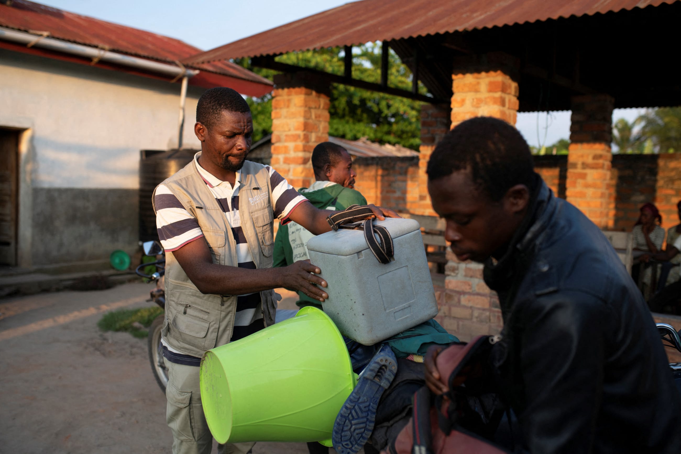 A local health official places a box containing samples onto a motorcycle in front of the Yalolia health centre, in Yakusu, Tshopo, Democratic Republic of Congo, on October 3, 2022.