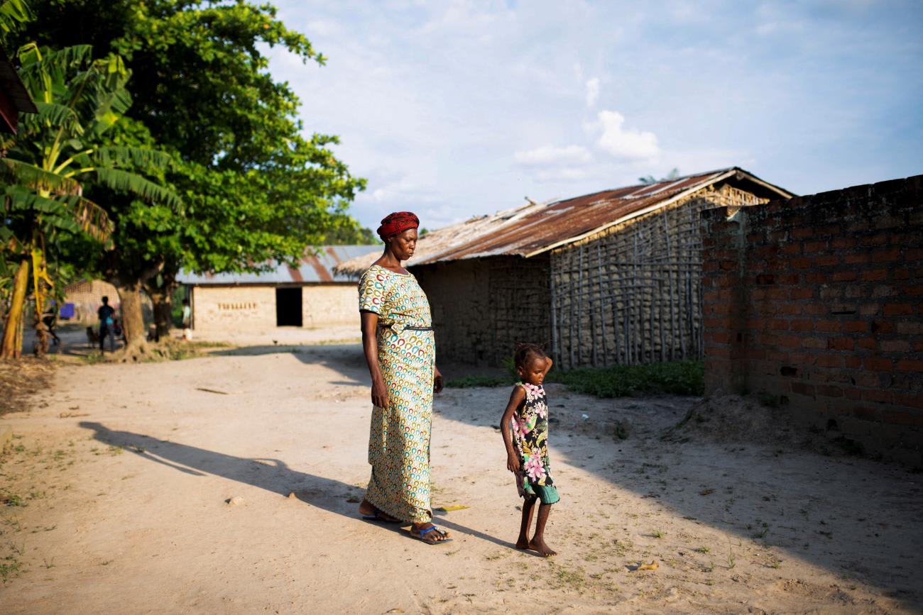 A woman walks her granddaughter to the restroom after having samples collected, at the Yalolia health centre, in Yakusu, Tshopo, Democratic Republic of Congo, on October 3, 2022.