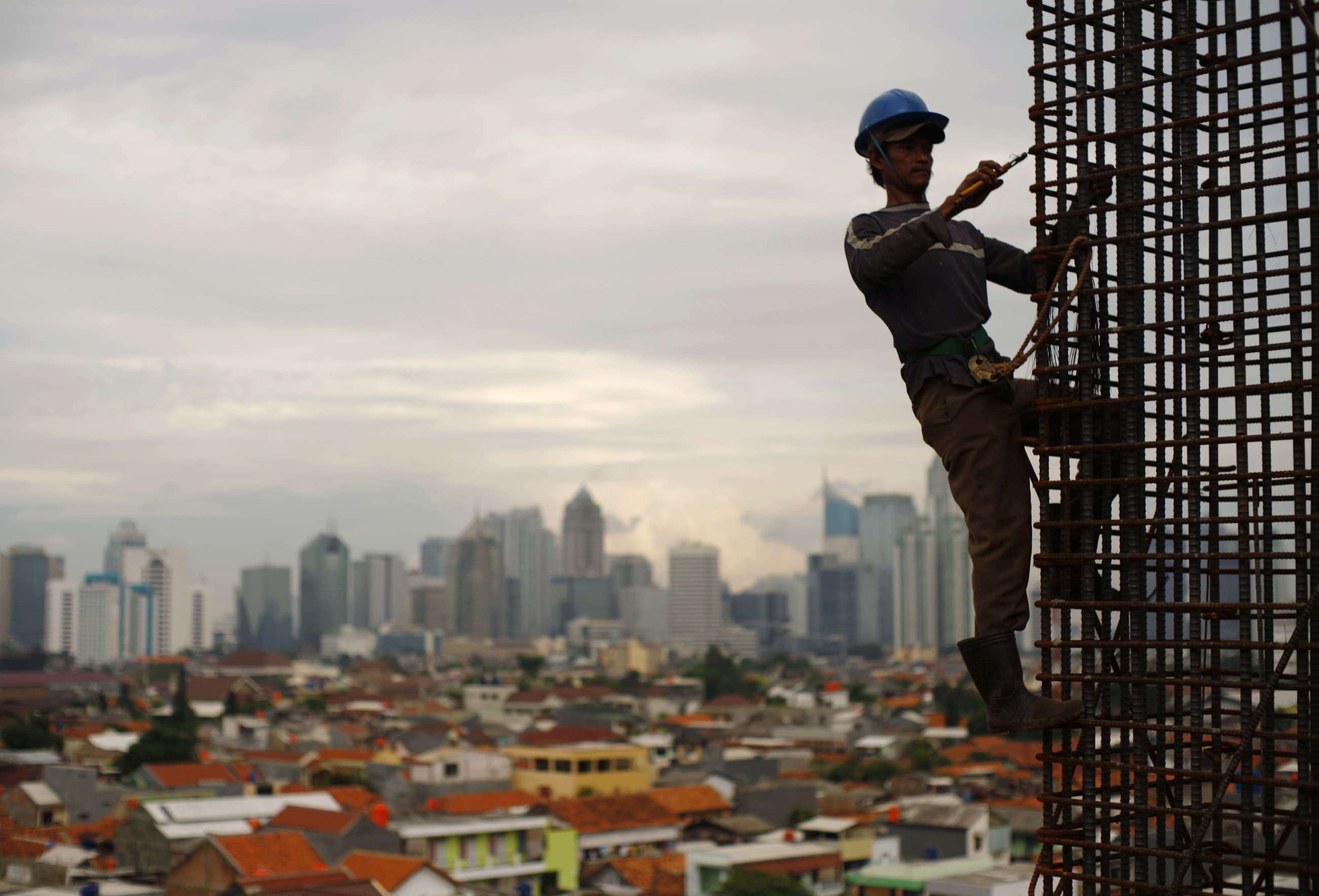 A worker stands on steel rods at a construction site, Jakarta, Indonesia, on February 2, 2010. 