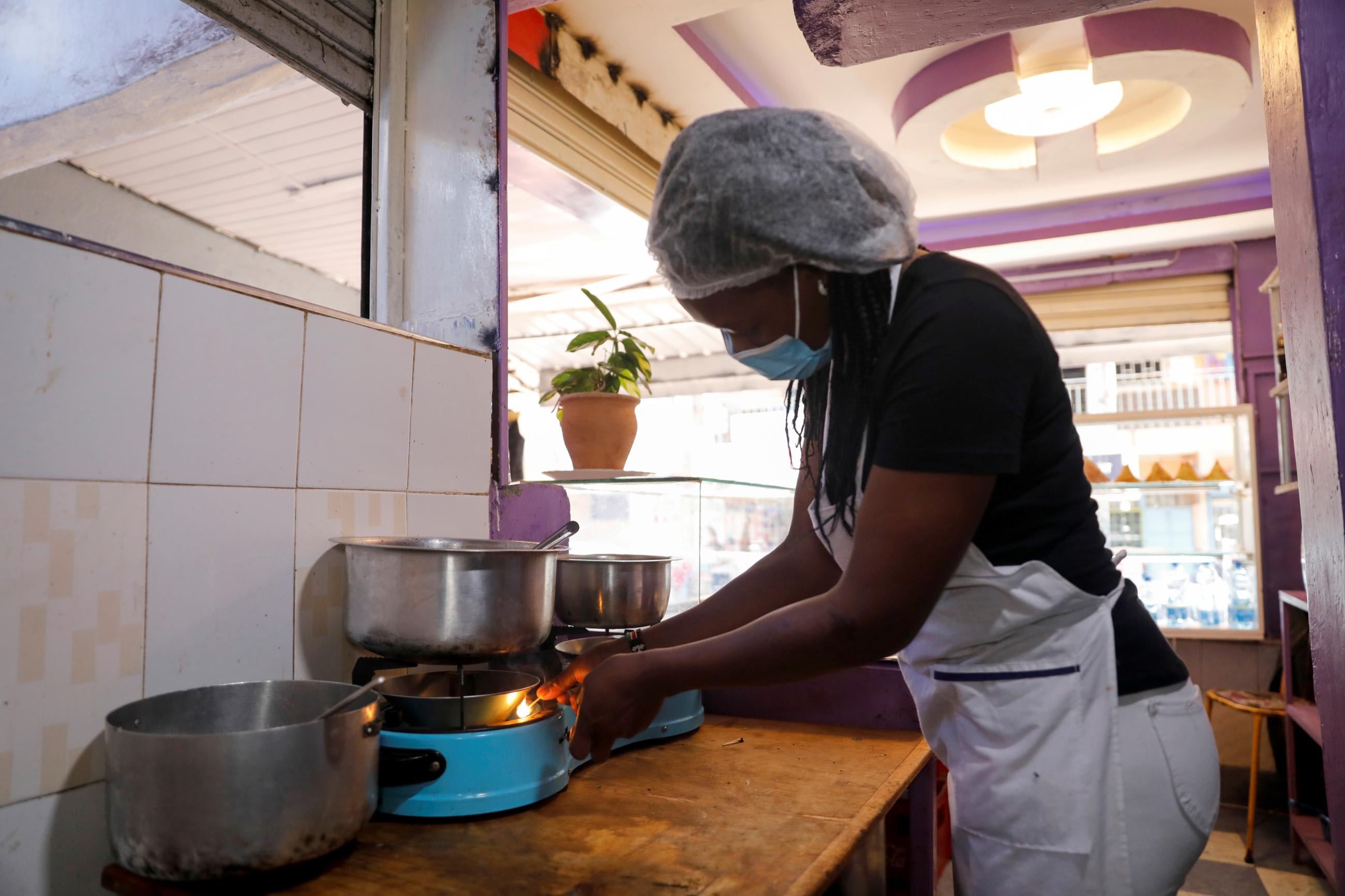 A woman cooks over a gas&nbsp;stove&nbsp;at a restaurant, using bioethanol fuel sold by the Koko startup company, in Nairobi, Kenya, on September 17, 2021.
