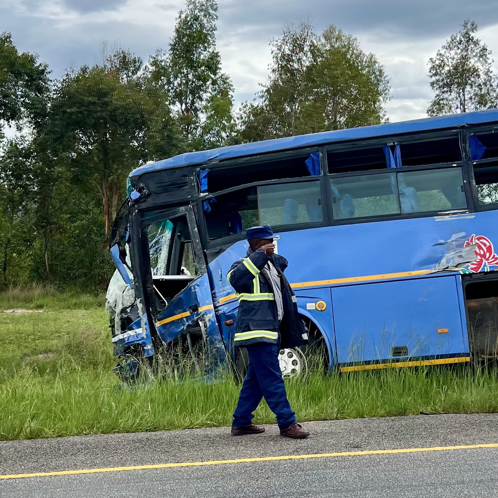 A man walks away from a bus that was involved in a disastrous head-on collision with a tractor trailer, in Macheke, Zimbabwe, in January 2024.
