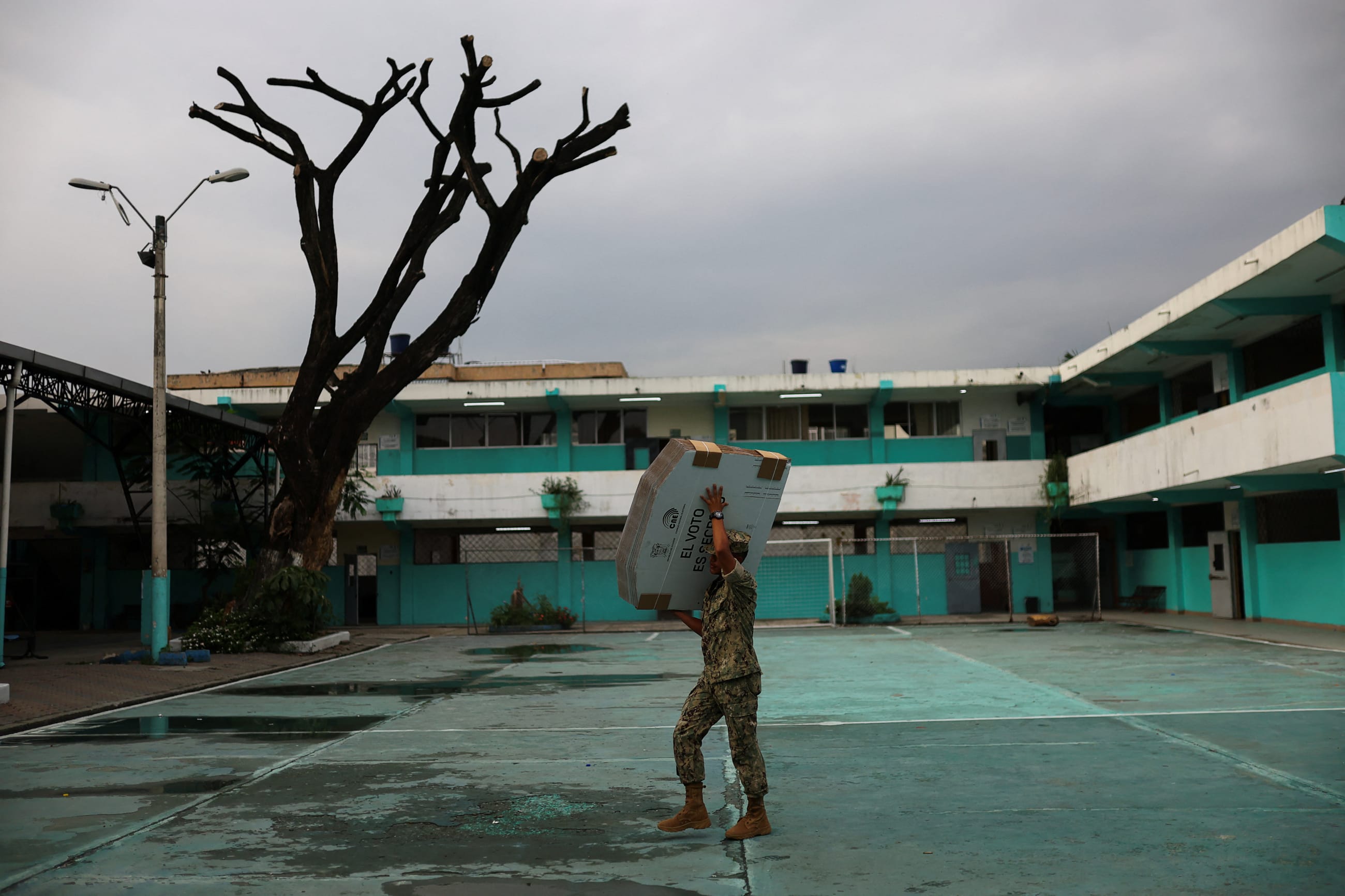 A member of the Navy carries electoral materials out to a school that is being used a polling station ahead of the presidential election, in Guayaquil, Ecuador, on February 8, 2025. 