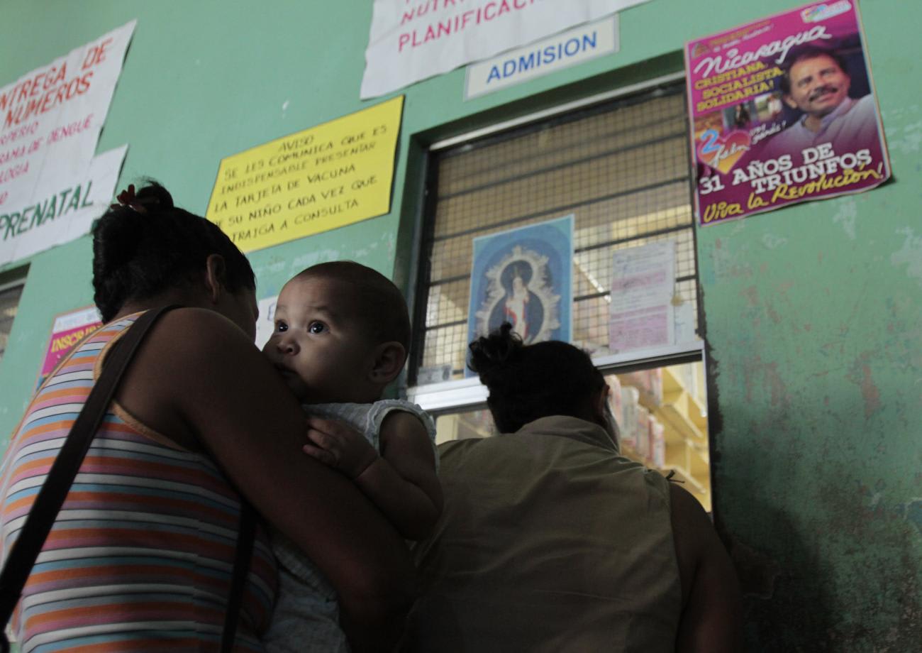 A mother carries her child while they wait to receive a pneumococcal&nbsp;vaccination, in Managua, Nicaragua, on January 13, 2011.
