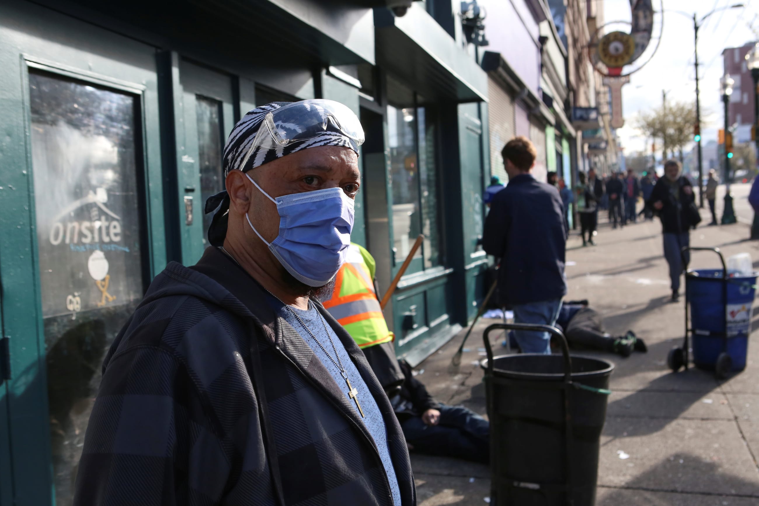 An InSite staff member directs drug users outside the supervised injection site on Hastings Street, in Vancouver, British Columbia, Canada, on March 25, 2020.
