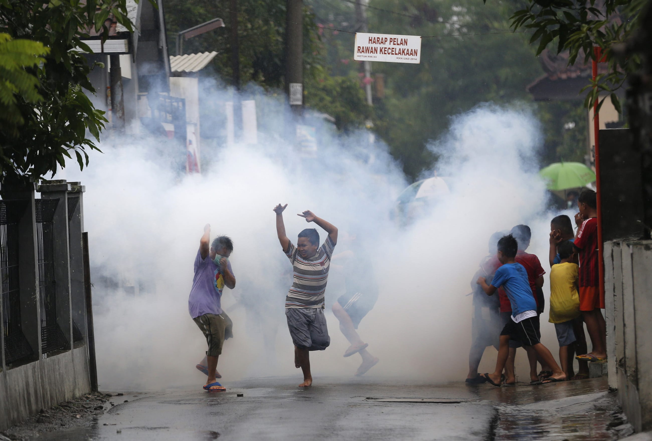 Children watch and play near a worker who is using the traditional method of chemical fogging to kill mosquitoes in Yogyakarta, Indonesia February 5, 2016.