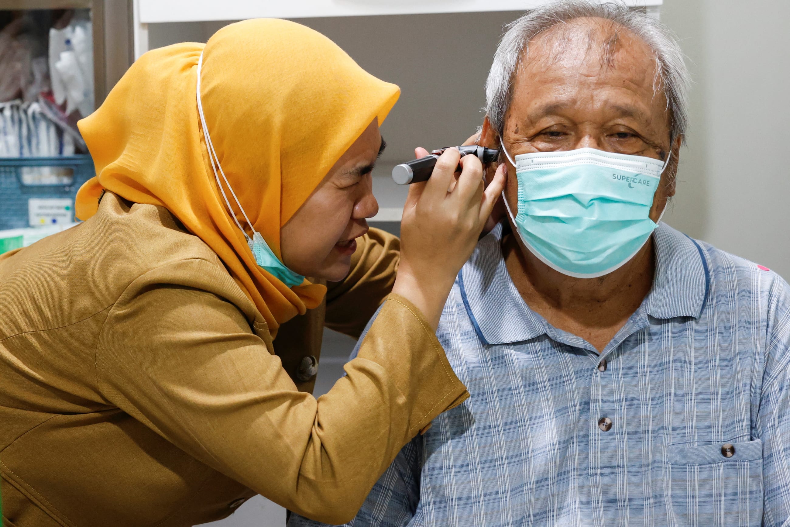 A doctor performs an otoscopy on an elderly man's ear during a free medical check-up, in Jakarta, Indonesia, on February 10, 2025.