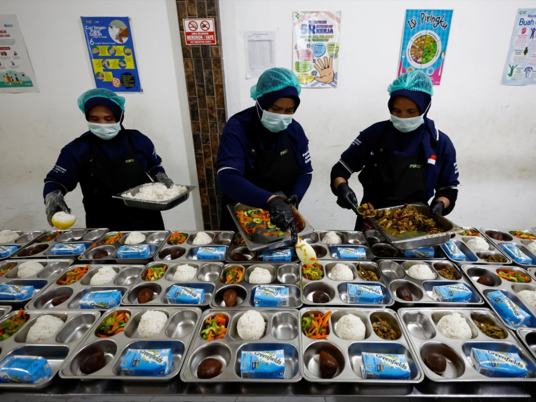 Workers prepare meals to be distributed free for students, during the free nutritious meals program trial, at a pilot kitchen in Sukabumi, West Java province, Indonesia, September 25, 2024.
