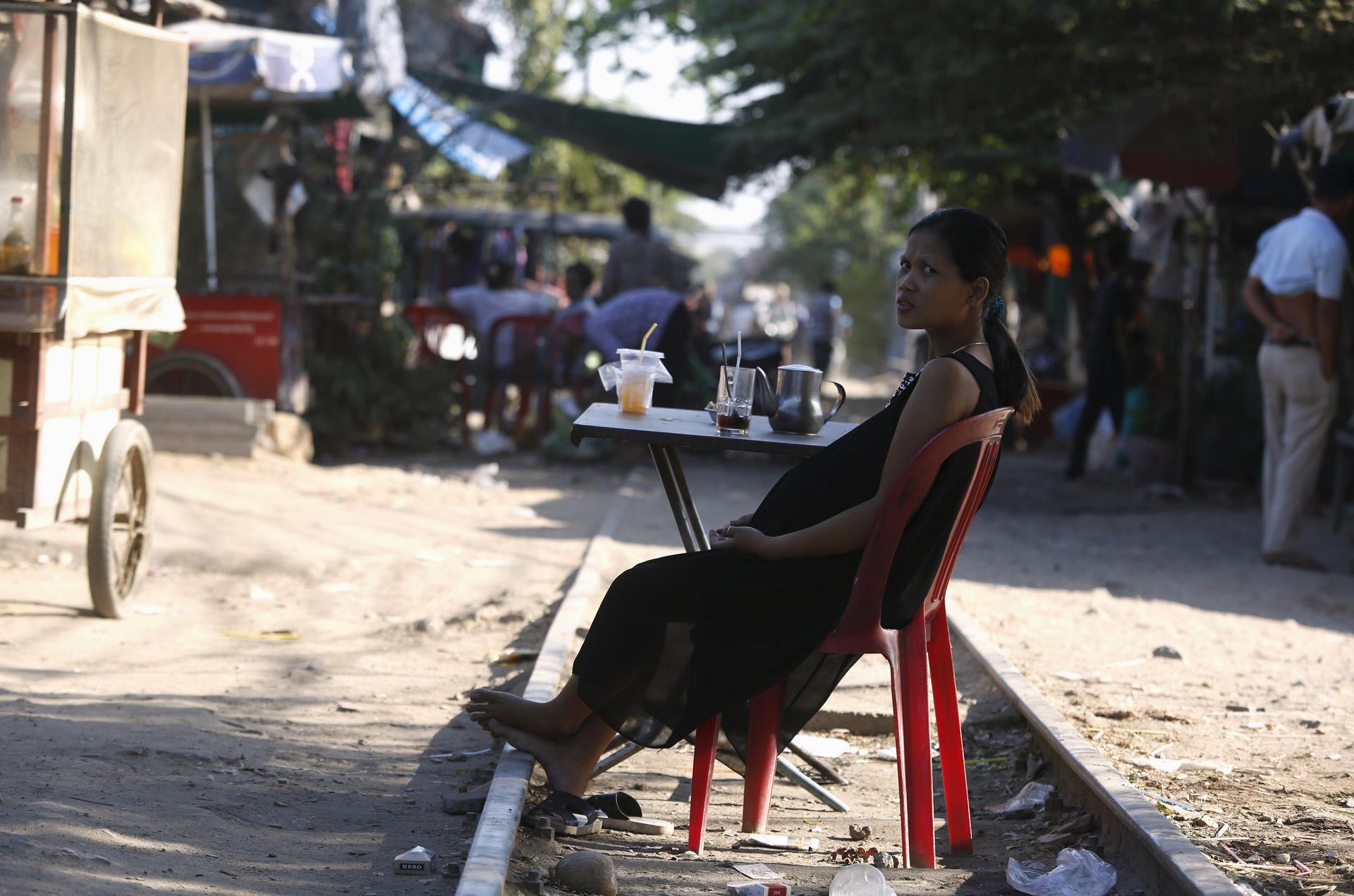 A pregnant woman rests on the railway track in front of her home, in Phnom Penh, Cambodia, on February 4, 2016.