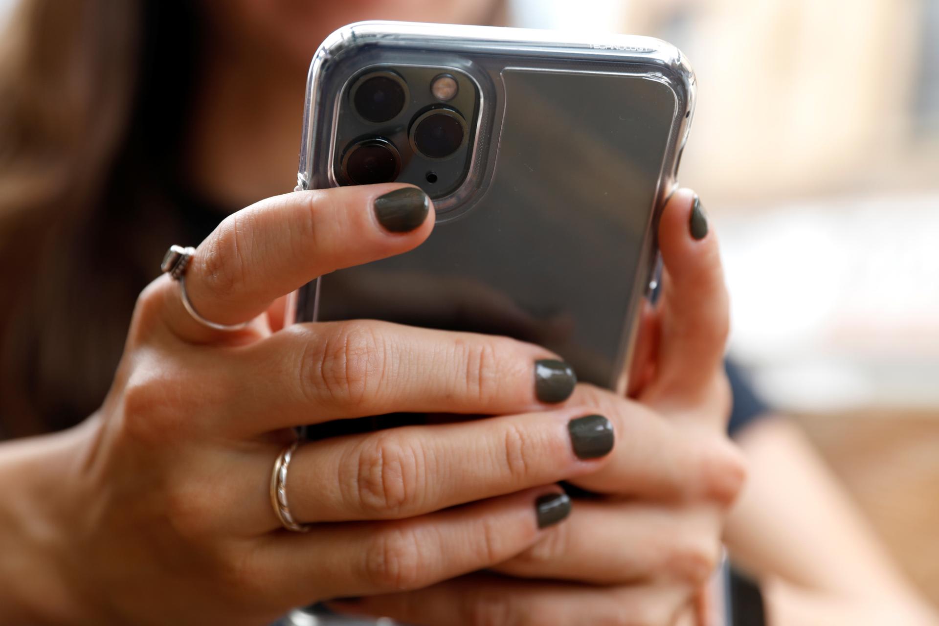 A person wearing gray nail polish and silver rings uses a cellphone in Manhattan, New York City, U.S., September 17, 2020. 