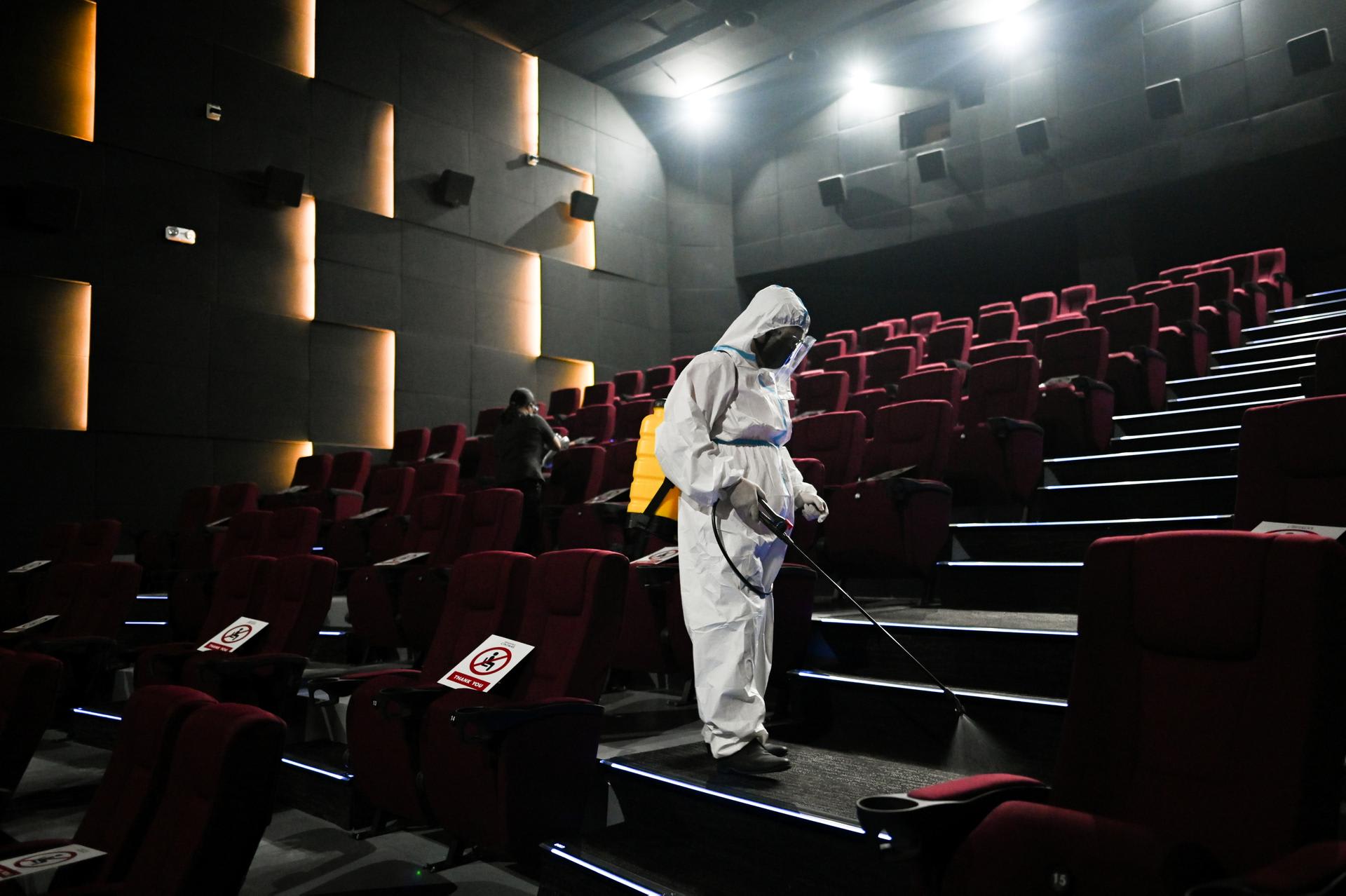 A worker in personal protective equipment disinfects a cinema in preparation for the reopening of movie theaters, as the country's capital region loosens coronavirus disease restrictions, at Eastwood Mall, in Quezon City, Philippines, on October 16, 2021.