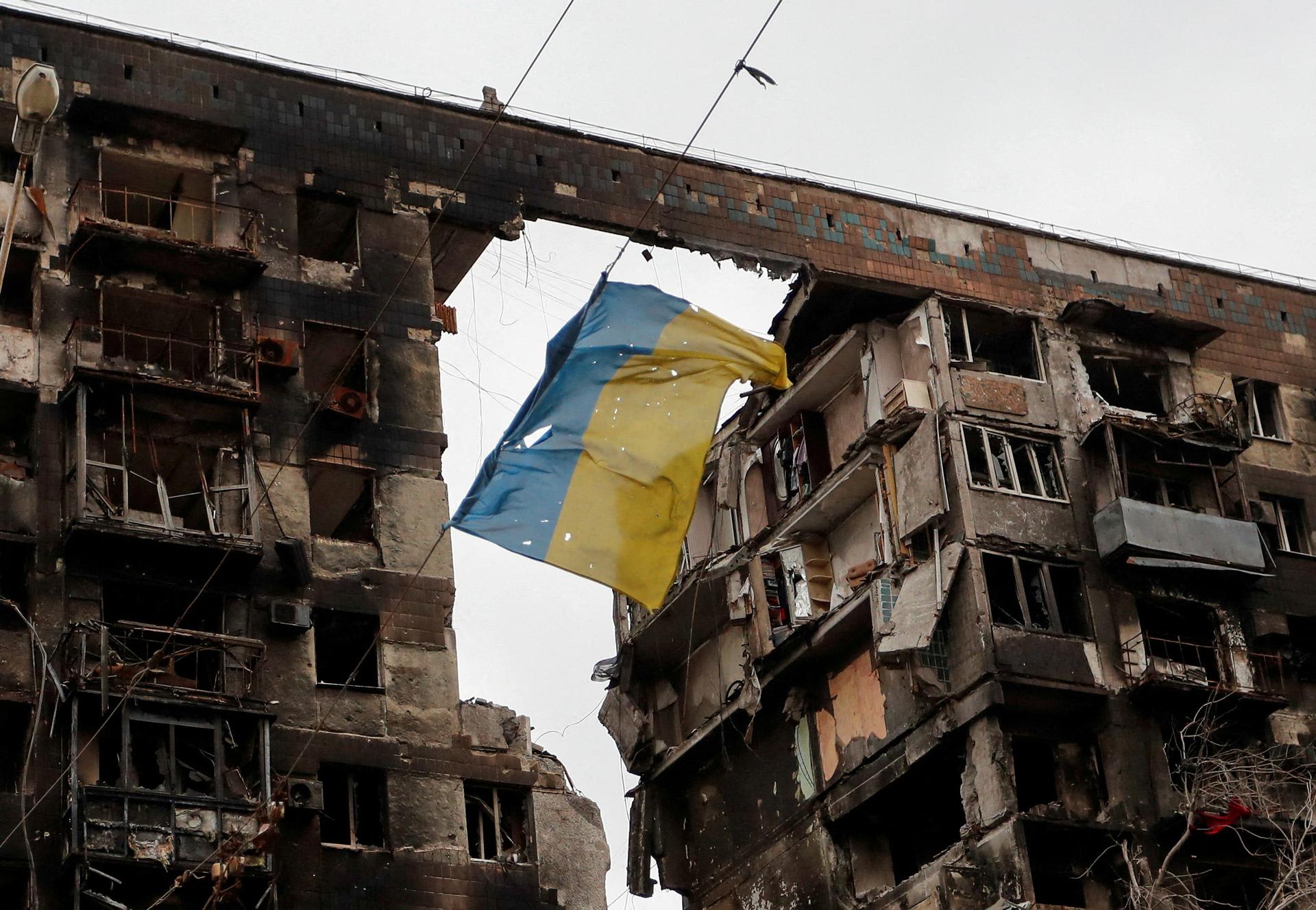 A view shows a torn flag of Ukraine hung on a wire in front an apartment building destroyed during Ukraine-Russia conflict, in Mariupol, Ukraine, on April 14, 2022. 