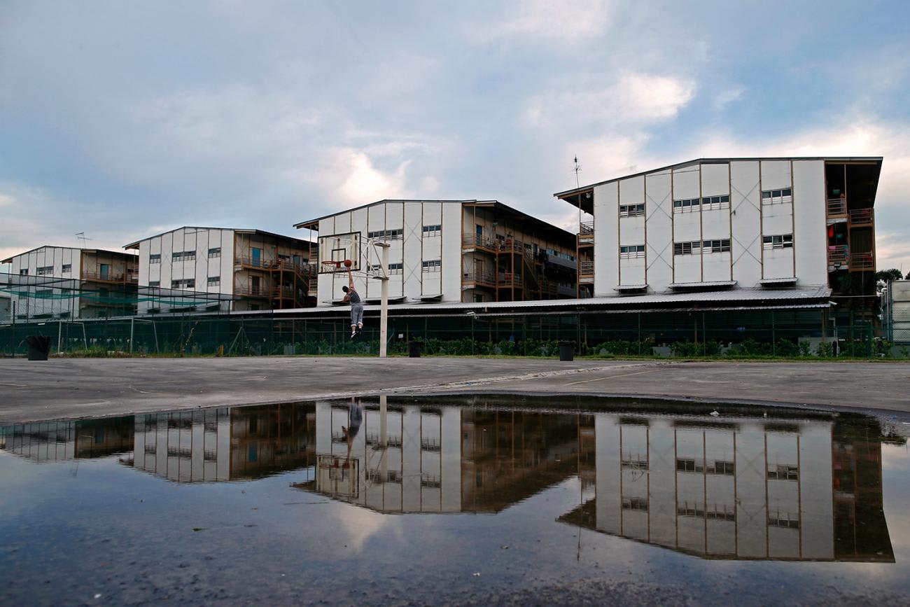 Photo shows Wang Zhijie, a migrant worker from Xi'an, China, going up to the hoop at a basketball court next to his dormitory in Singapore.