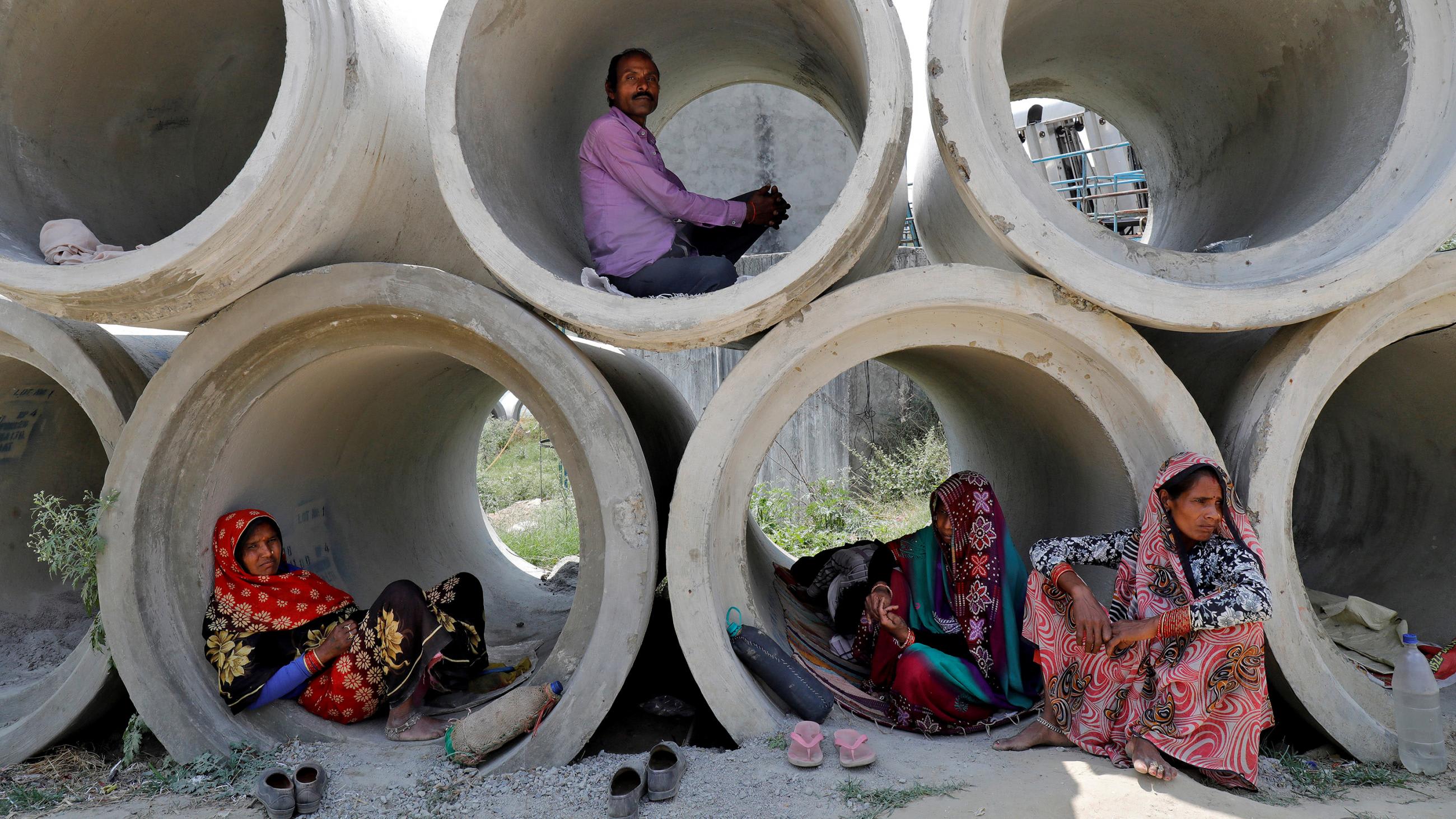 This is a powerful image of people inside stacked cement pipes of large enough diameter for them to camp out in.
