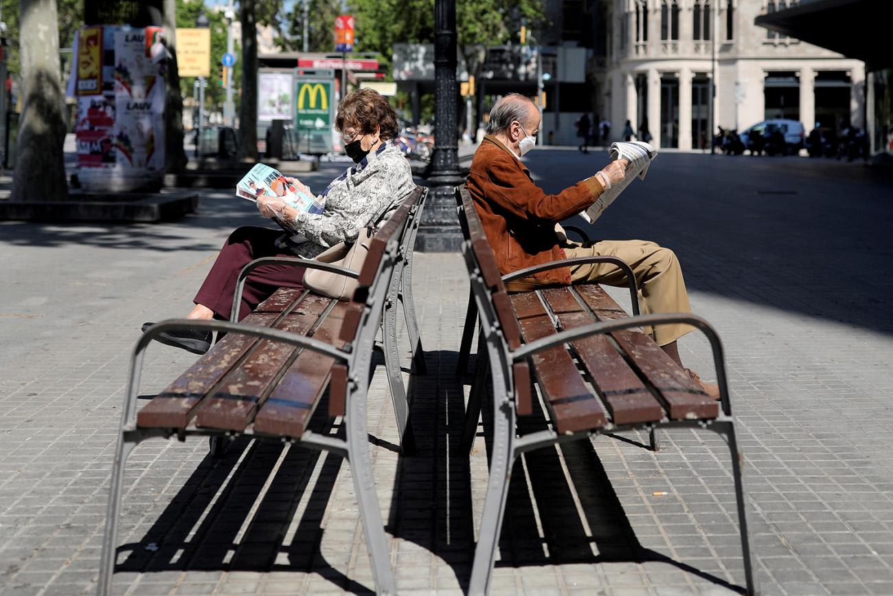 The picture shows two people on benches facing in opposite directions.