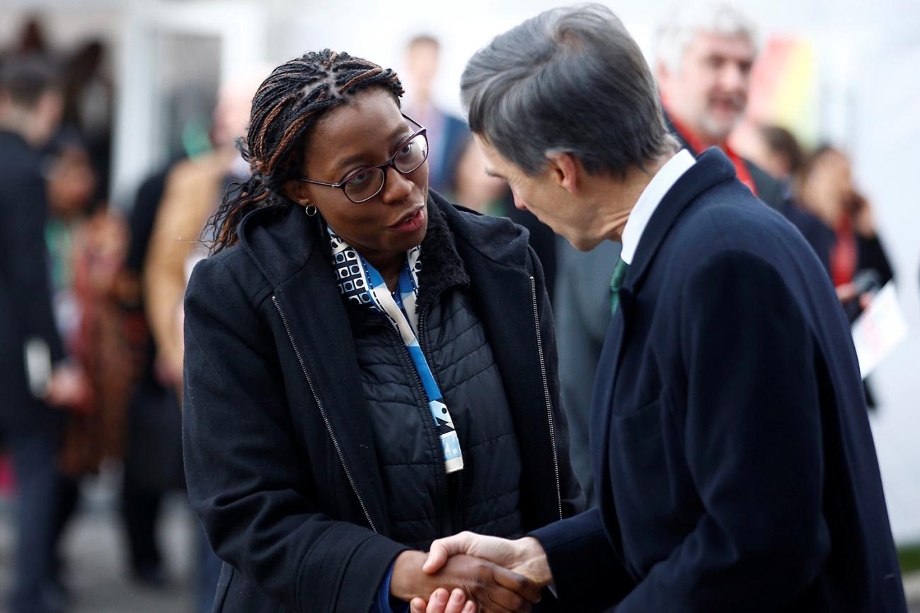 The photo shows Songwe and another delegate shaking hands.