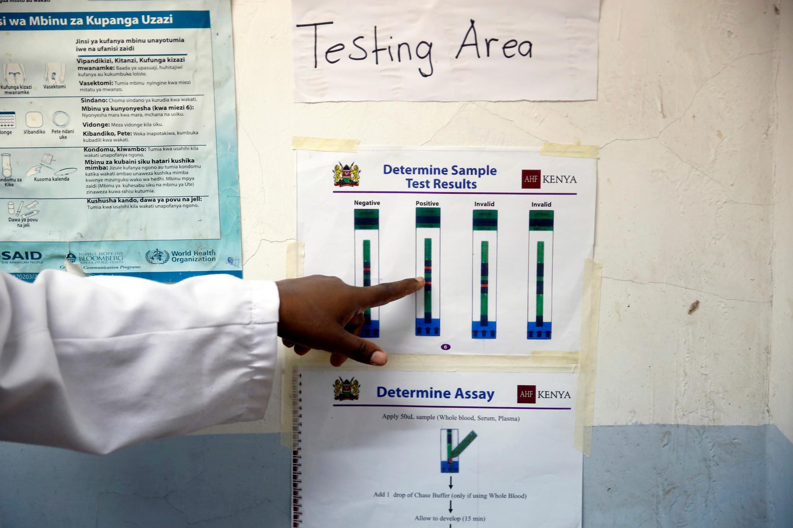 An HIV adherence counsellor points to a poster of test results to a woman who was tested for HIV at the IOM treatment centre in Eastleigh, Nairobi, Kenya, on November 29, 2018. 