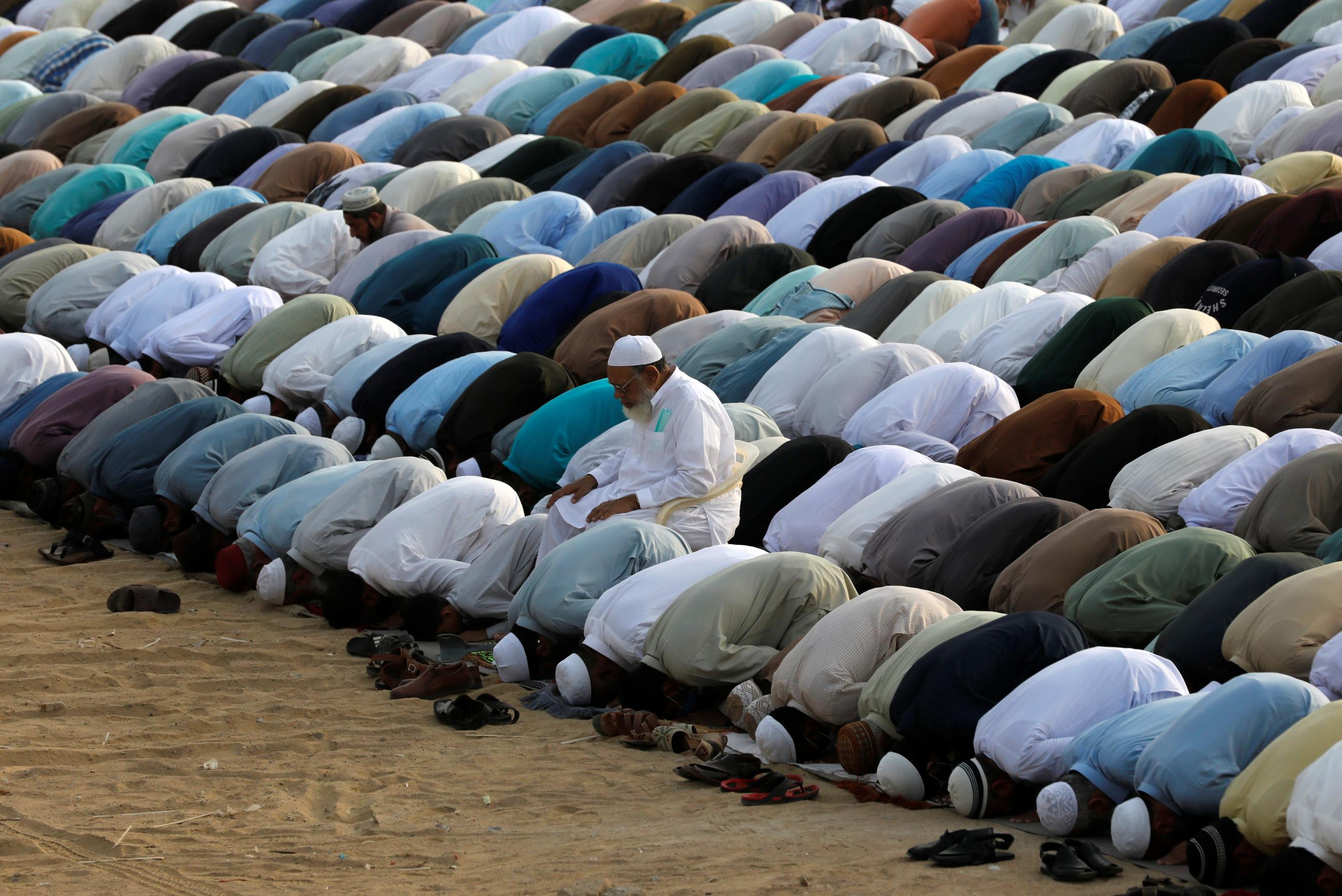 Muslims bend forward in prayer celebrating Eid al-Fitr, marking the end of the holy fasting month of Ramadan during the COVID-19 pandemic in Karachi, Pakistan, on May 13, 2021.