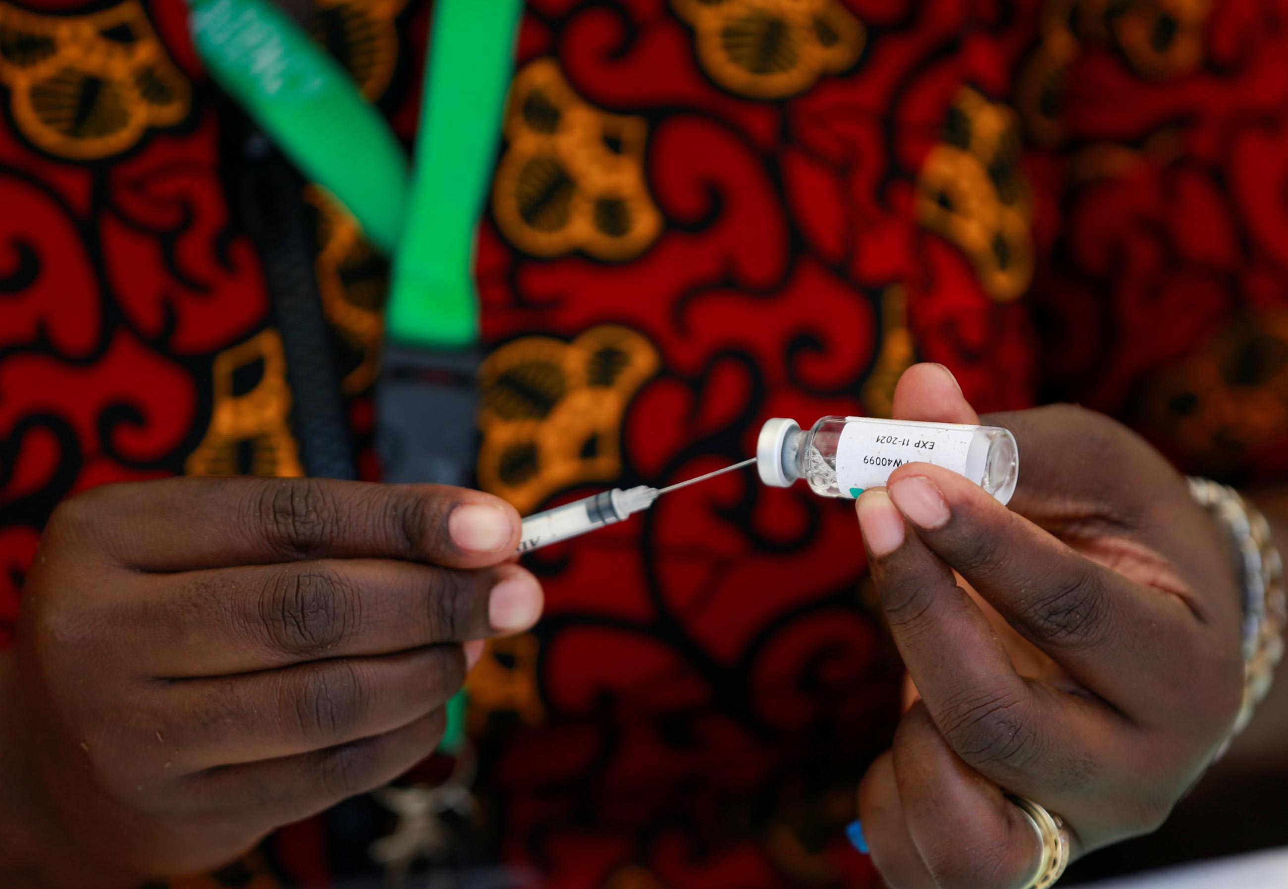The hands of a health worker are seen as they take a COVID-19 vaccine dose from a vial during a vaccination event in Abuja, Nigeria, November 19, 2021.