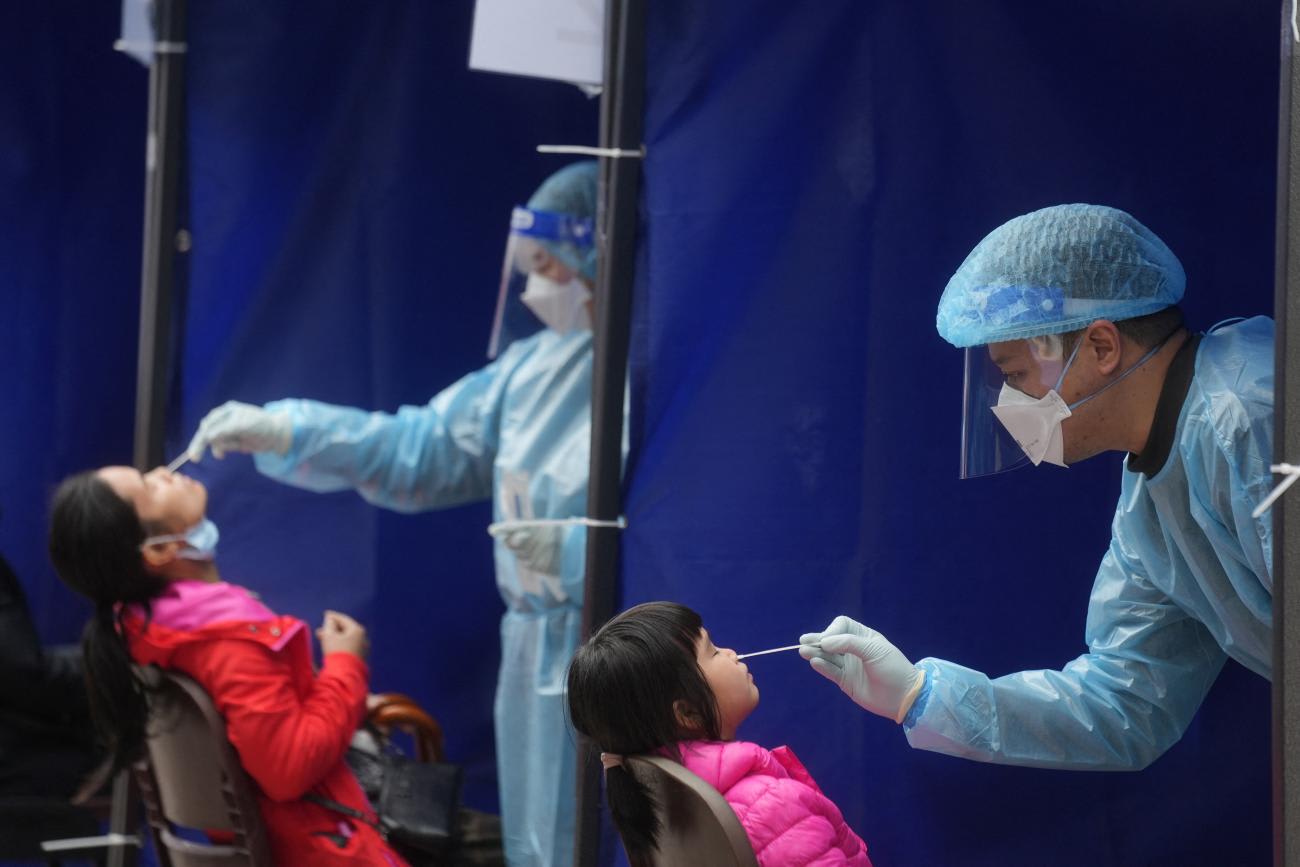 Medical workers take swab samples from residents at a community nucleic acid testing centre for the coronavirus disease at Sha Tin District, in Hong Kong, on February 7, 2022. REUTERS/Lam Yik