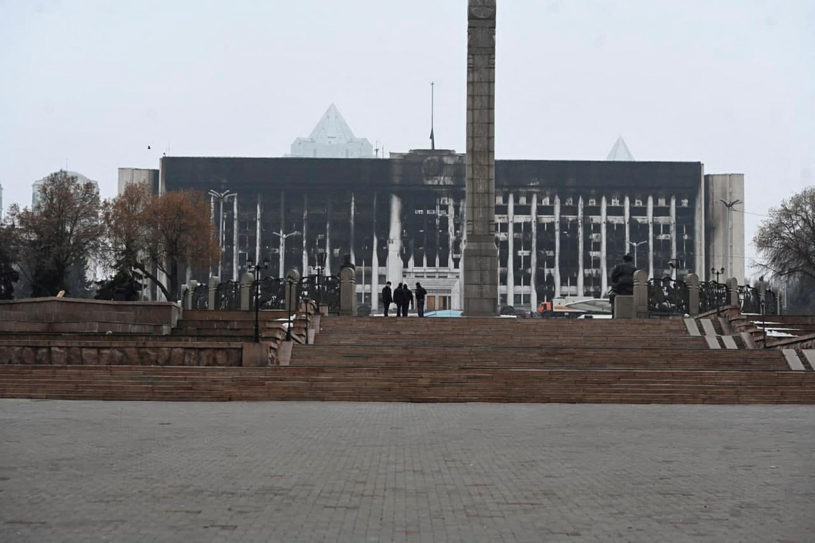 A view of the fire-damaged mayor's office building—its white facade significantly burnt—seen from Republic Square, in Almaty, Kazakhstan, following protests triggered by a fuel price increase, on January 10, 2022.