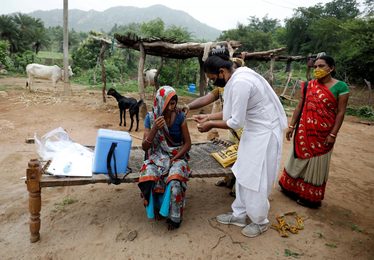 Health worker Jankhana Prajapati gives a dose of the COVISHIELD vaccine to villager Amiyaben Dabhi during a door-to-door vaccination drive in Banaskantha district, in Gujarat, India, on July 23, 2021.