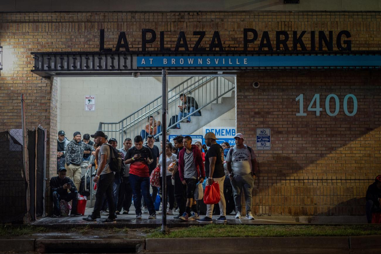 Migrants stand at a processing center as they wait for a bus to Chicago, in downtown Brownsville, Texas, U.S., October 24, 2023. The Republican-led state of Texas said it has spent at least $100 million since April 2022 to bus tens of thousands of migrants who recently crossed the U.S.-Mexico border to Chicago, New York, Denver, and other Democratic-led cities.