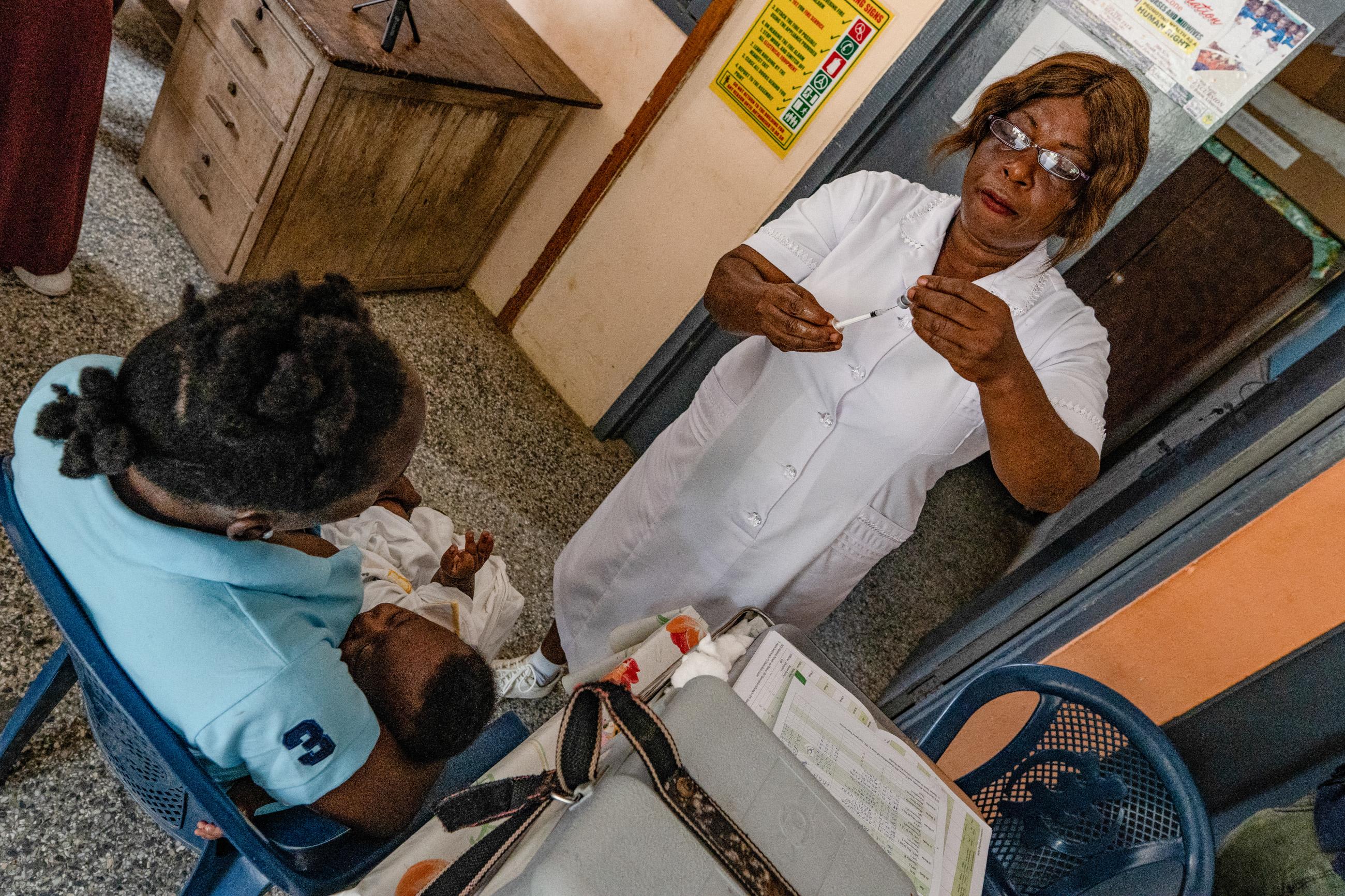 A nurse holds a syringe as patients wait, after zipline drones, supported by Gavi and the UPS Foundation, cut the time taken to deliver lifesaving medical supplies, in Ghana, on April 23, 2019.