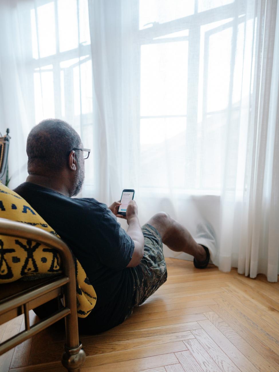 An elder Black man uses a phone to learn more about sexual health, October 4, 2022