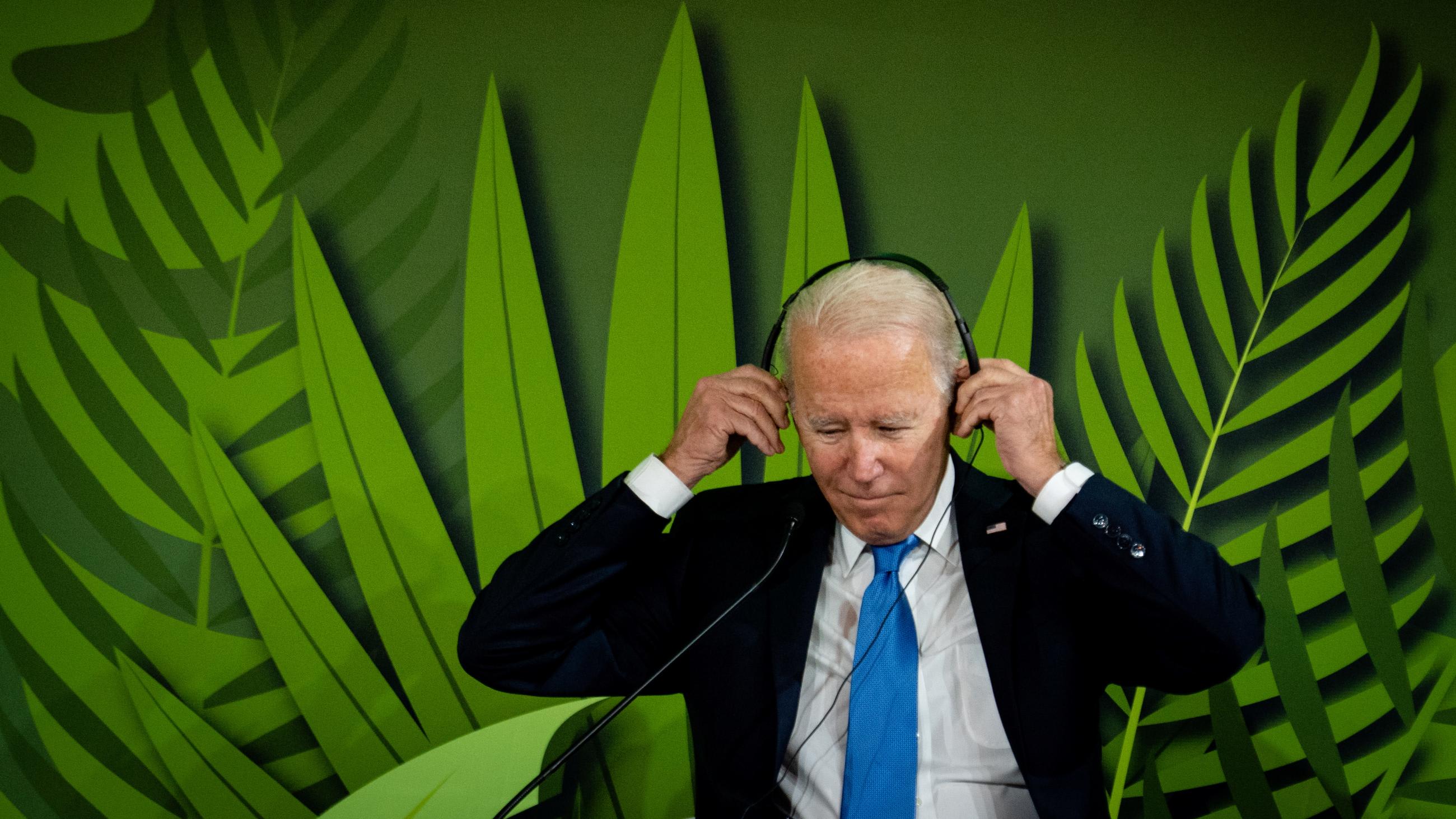 U.S. President Joe Biden puts on headphones to listen to speeches during the