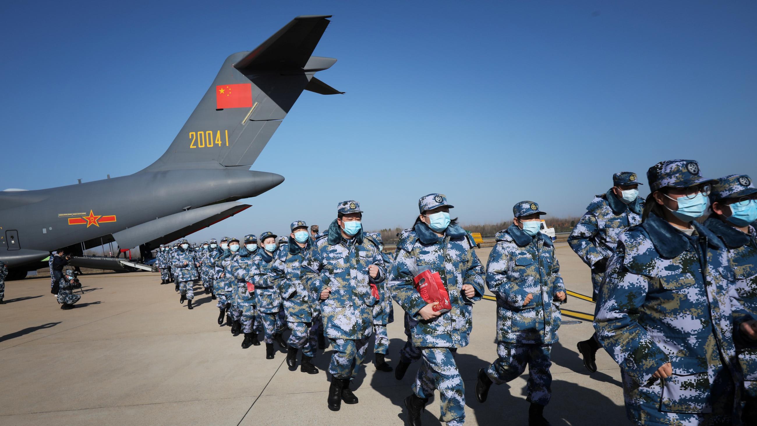 Medical personnel in blue camouflage uniforms arrive with medical supplies in transport aircraft of the Chinese People's Liberation Army (PLA) Air Force.