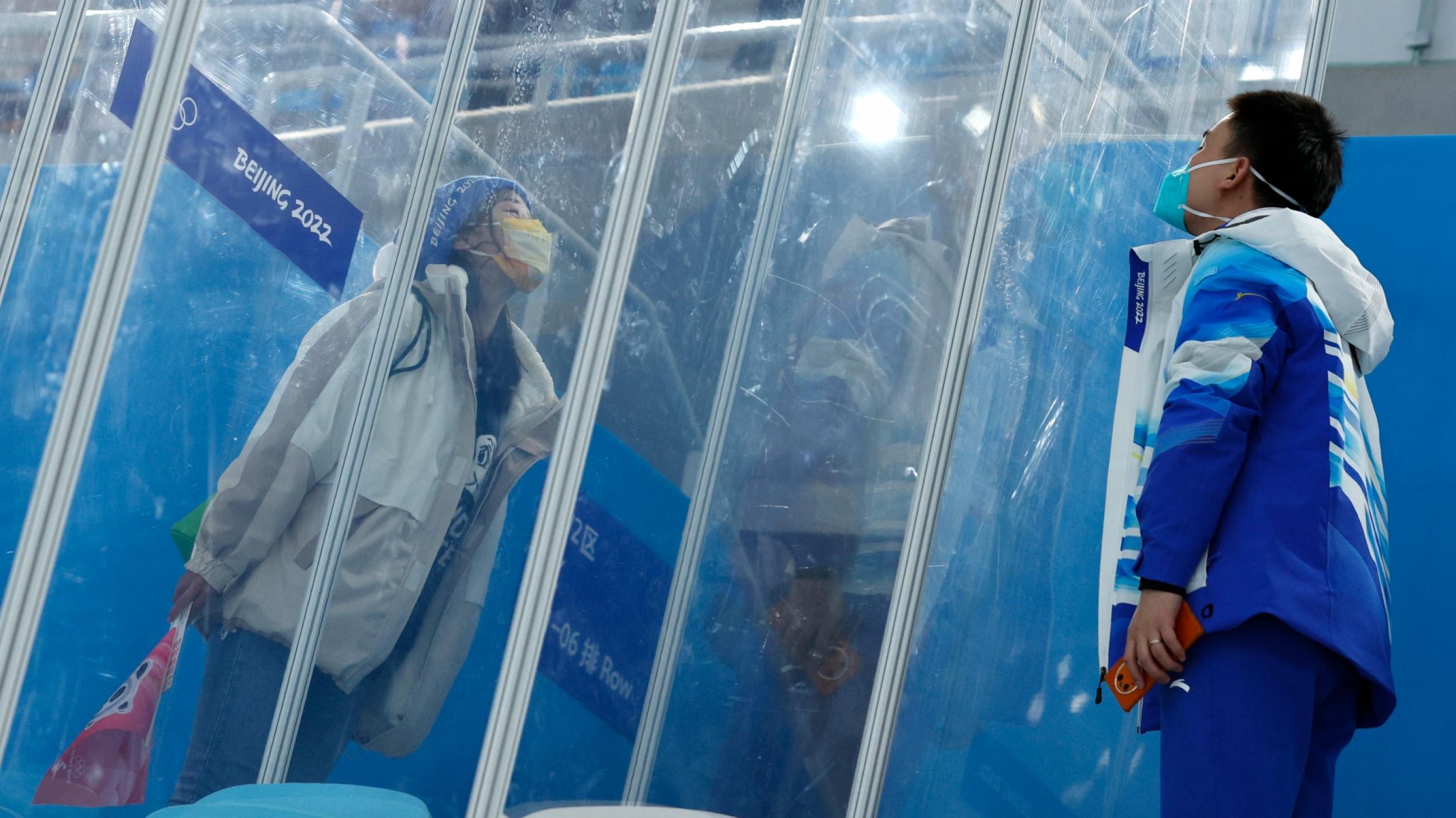 Dr. Ding Hongtao, part of the medical staff, blows a kiss to his girlfriend through screens of glass that separate them because of the 