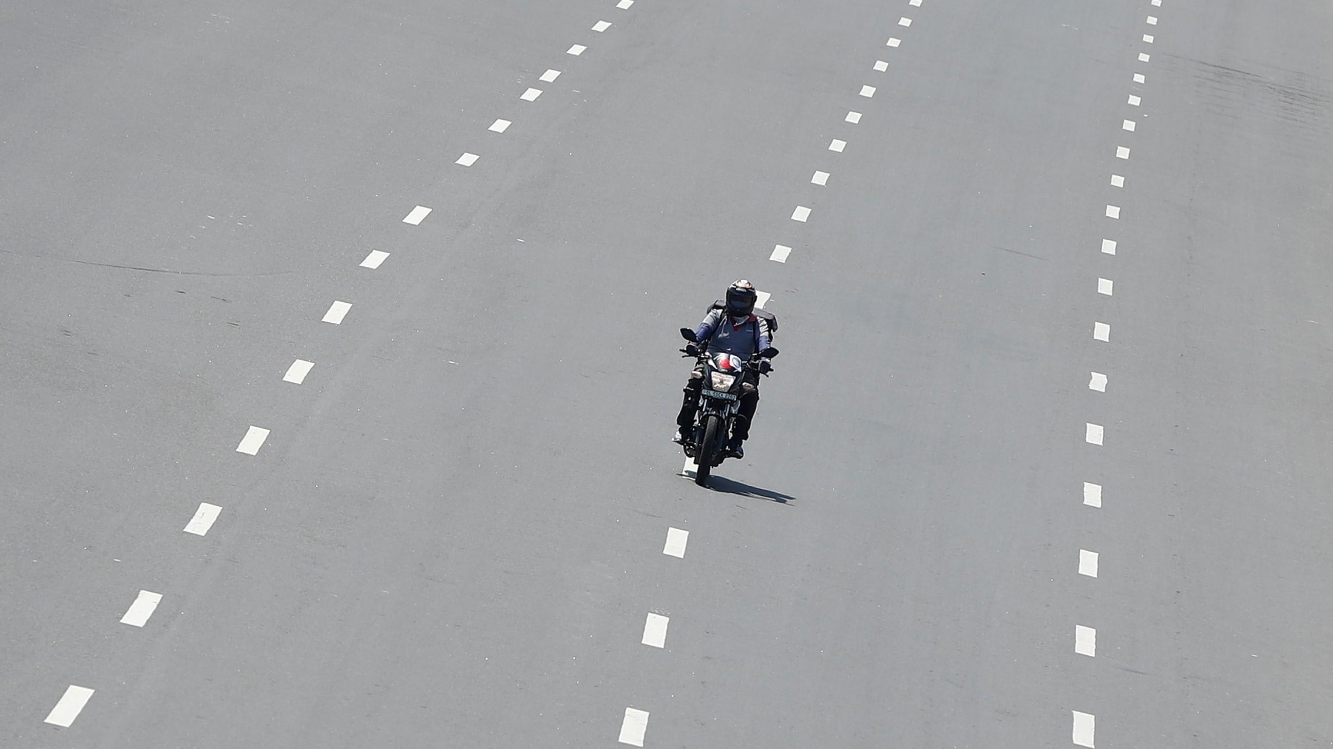 Delivery worker Devender Singh, who works for Licious, an online meat store, rides his bike on a deserted road, in New Delhi, India, on April 6, 2020.