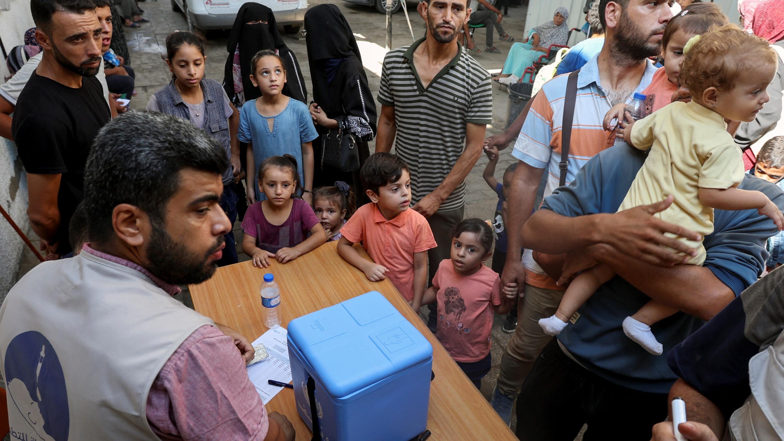 Palestinian children, accompanied by parents, wait to be vaccinated against polio.