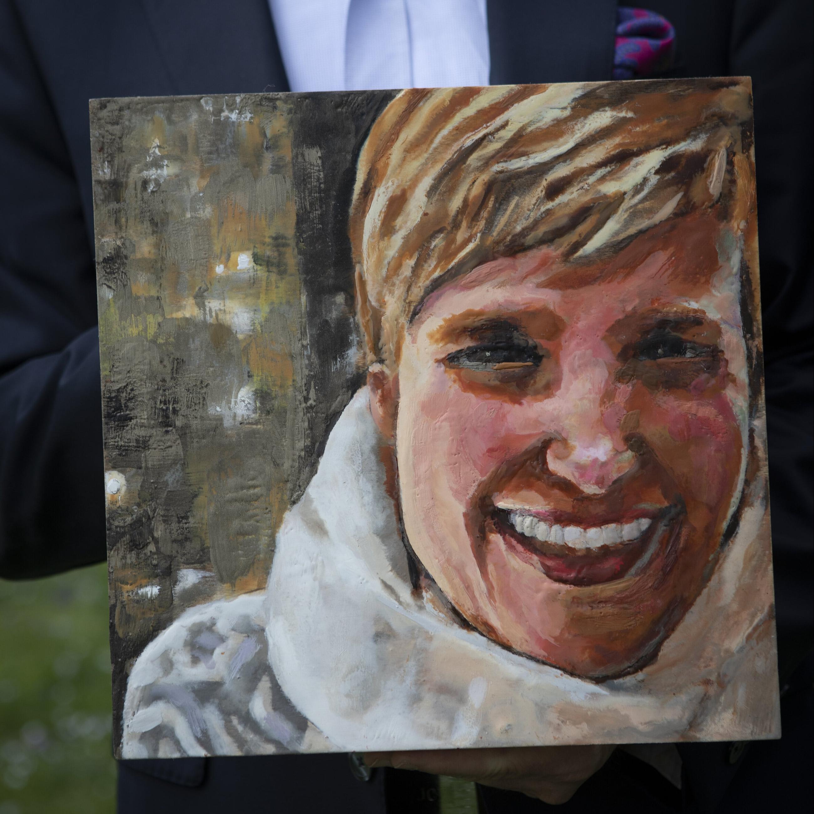 Corey Feist, cofounder of the Doctor Lorna Breen Heroes Foundation, holds a painting of his late sister-in-law at his home in Charlottesville, Virginia, on April 7, 2021.